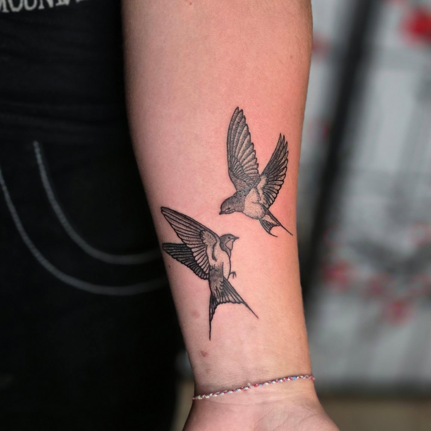 Swallows black and grey tattoo on the forearm by Bryan "Yogi" Fuhs