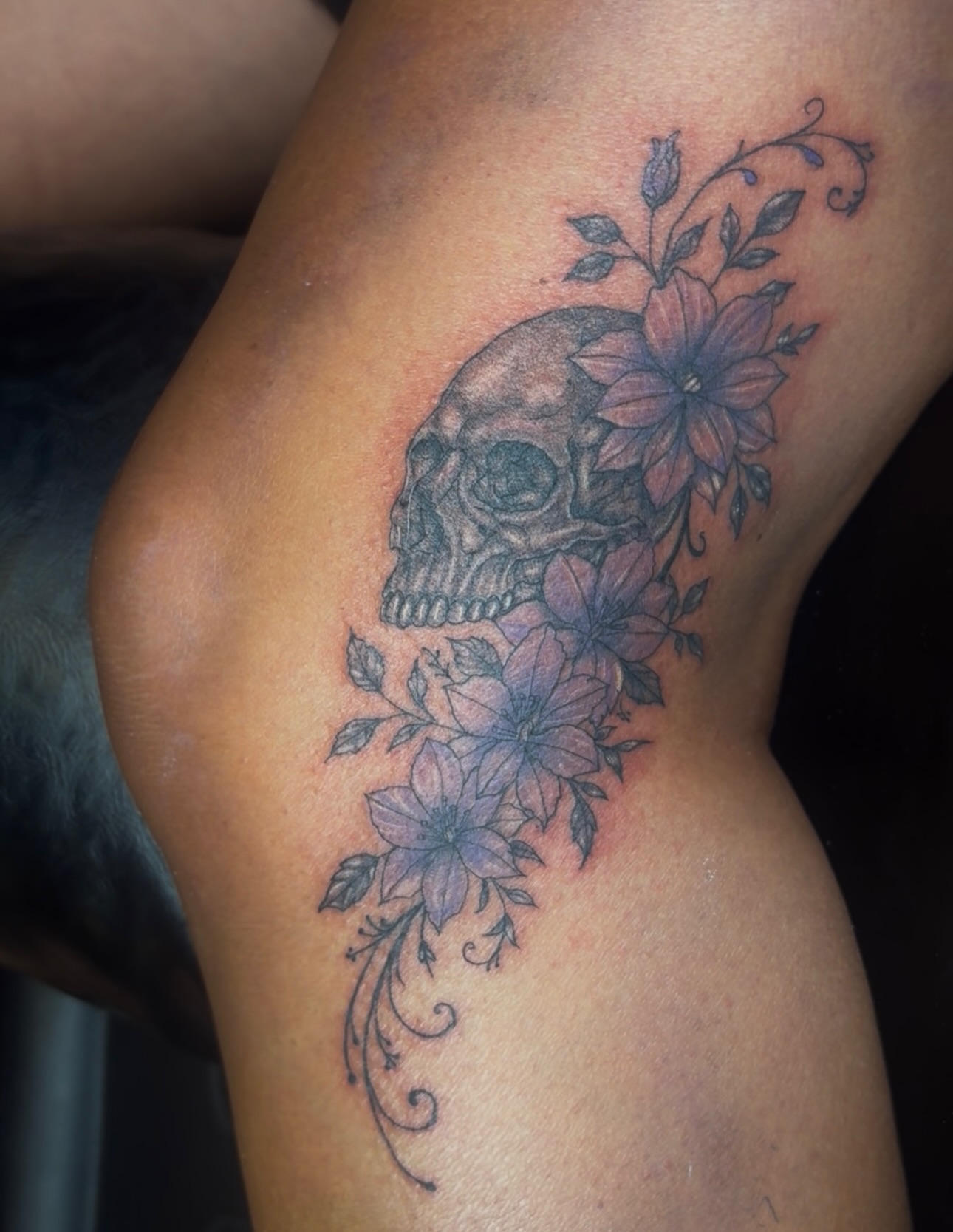 Skull and flowers black and grey tattoo on the thigh by 𝔾𝔥𝓸ş𝔱