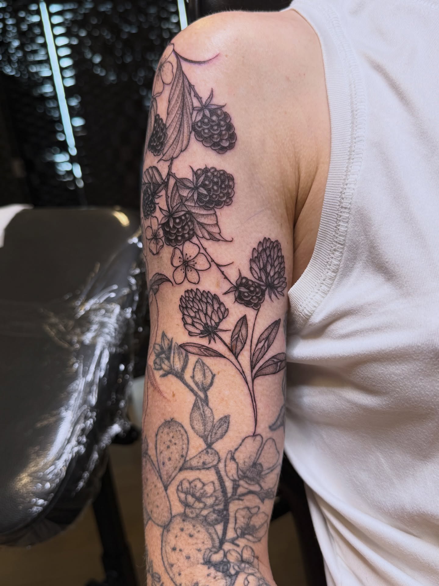 Berry and clover bouquet black and grey tattoo on the forearm by WhoisLaineyTattoos