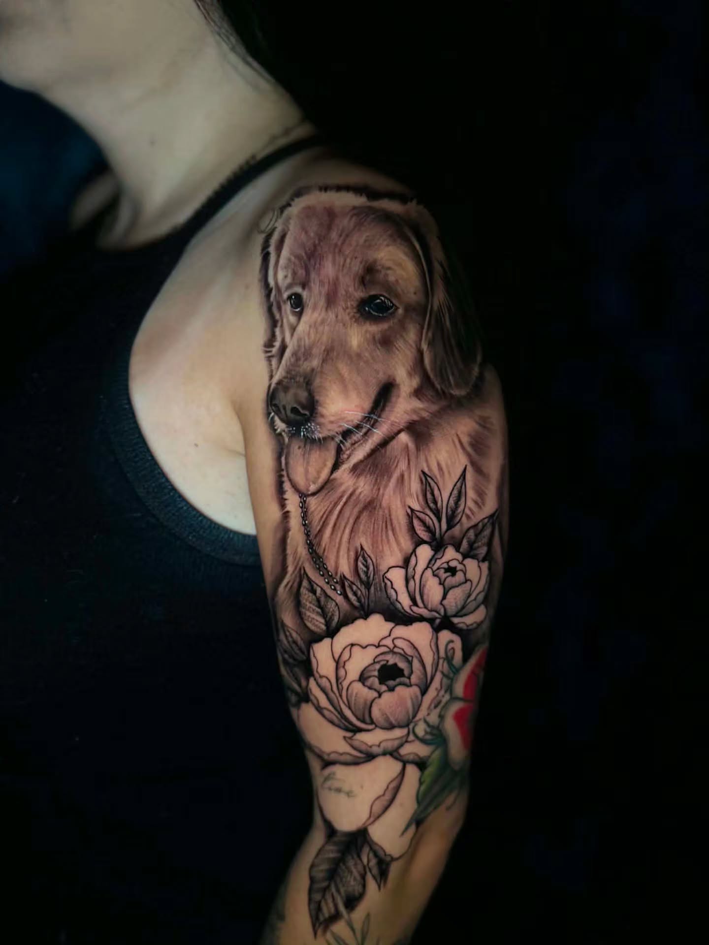 Dog and flowers realism tattoo on the forearm by Jon Goad