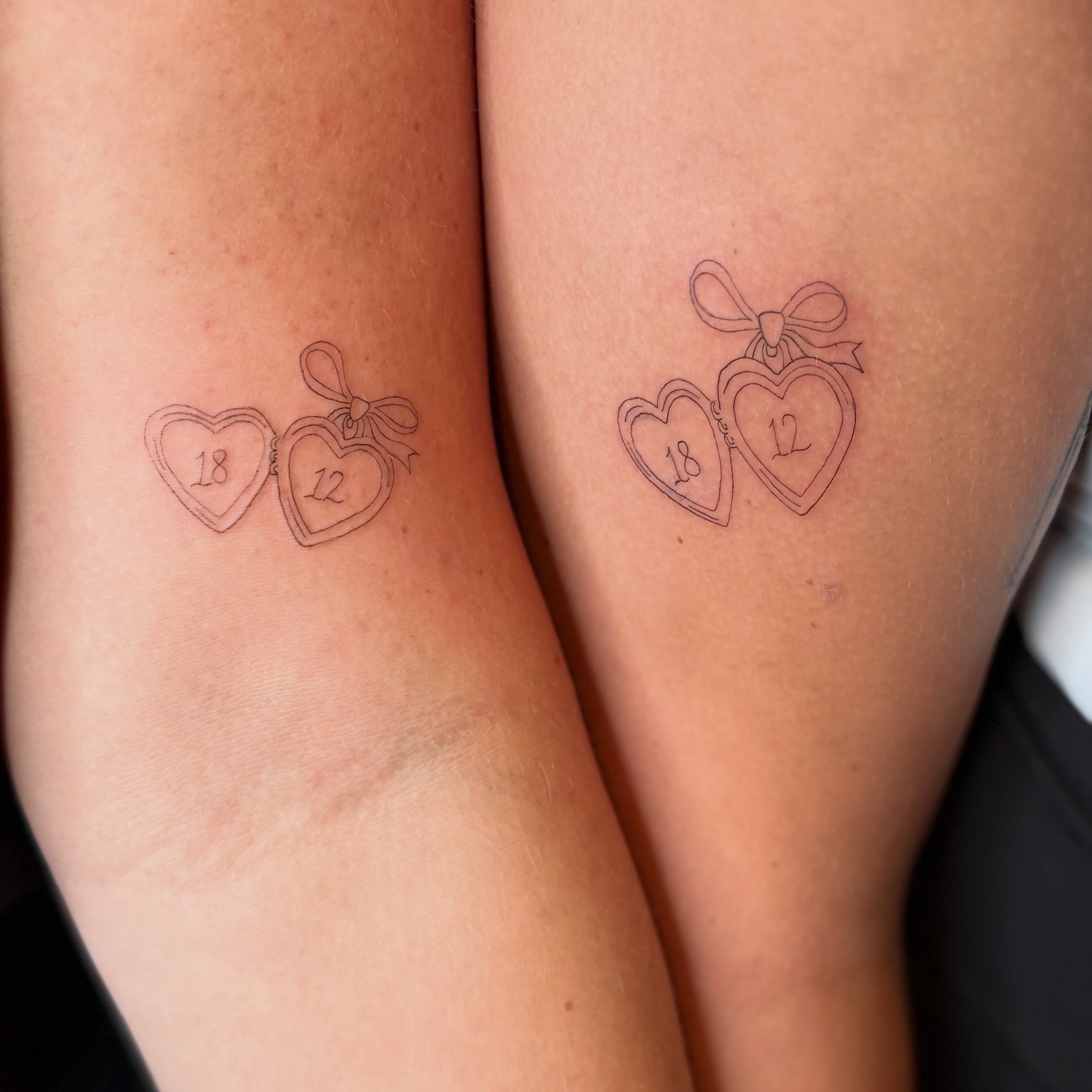 Heart pendants fine line tattoo on the forearm by Fineline Tattoo