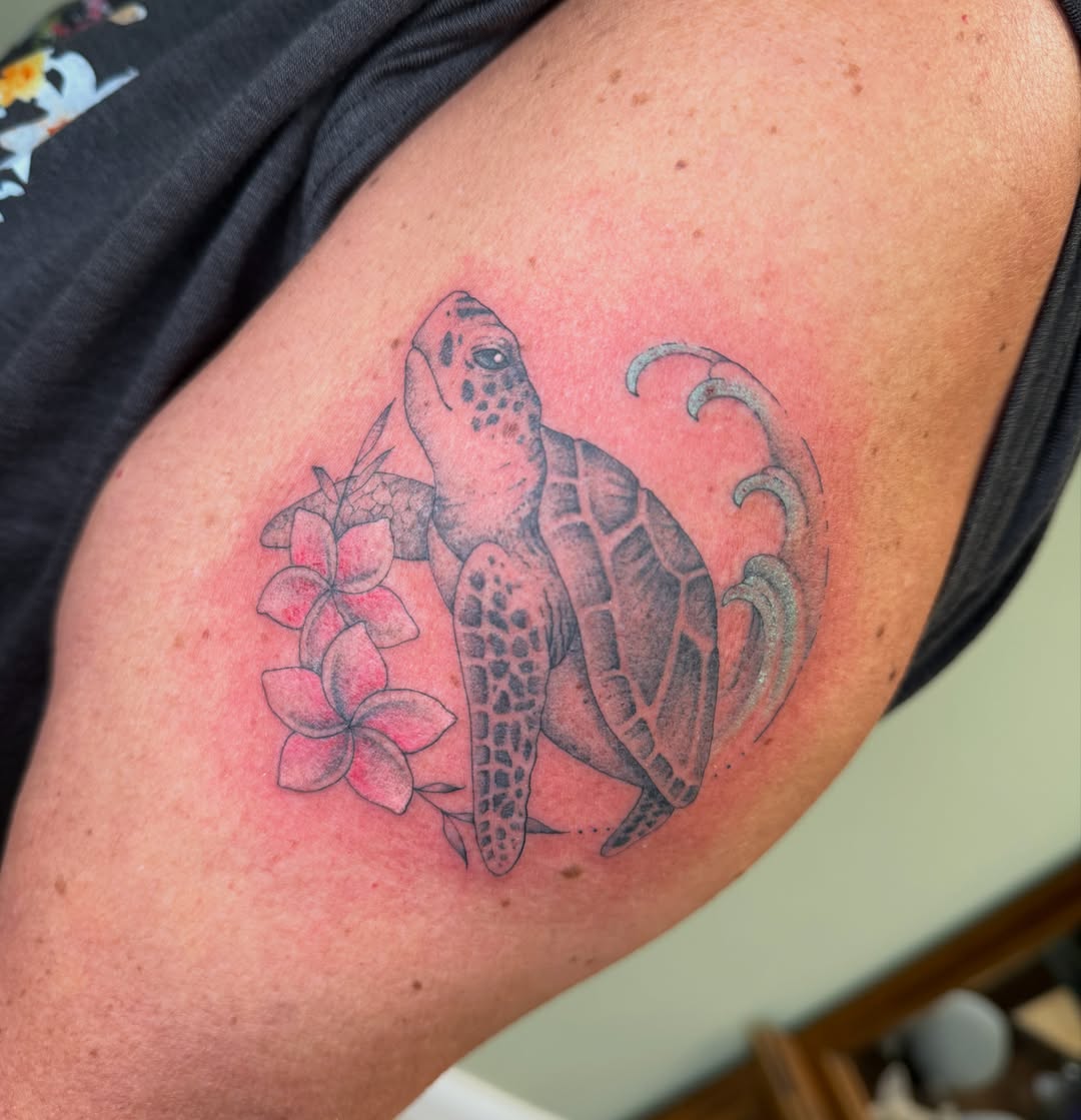 Turtle and flowers black and grey tattoo on the upper arm by Koryn Donnelly