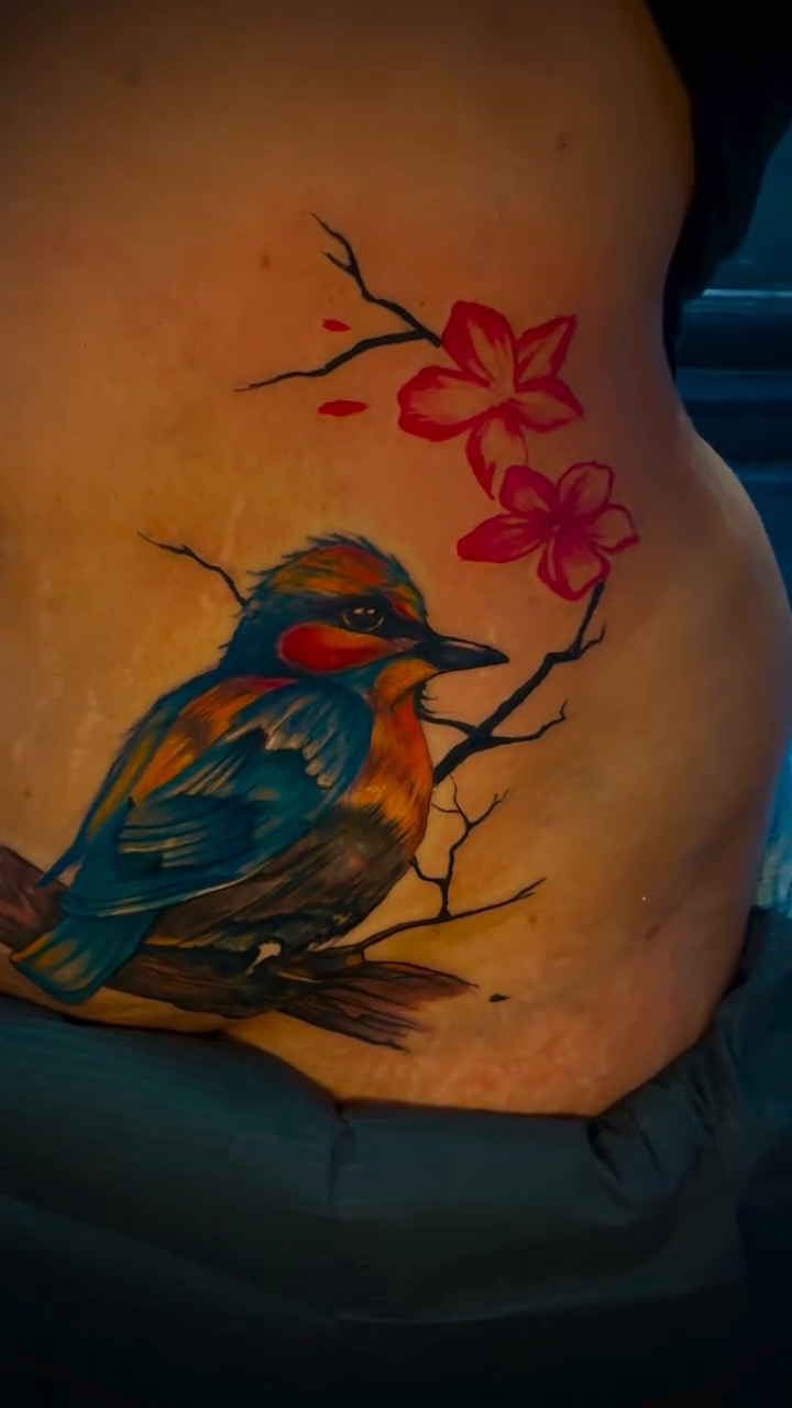 Bird on a branch with flowers realism tattoo by Devin Johnson, Forest Park, Georgia