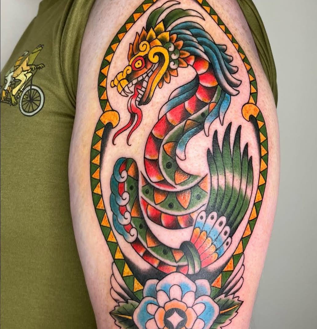 Serpent and flower American traditional tattoo on the upper arm by Hunter McGinnis