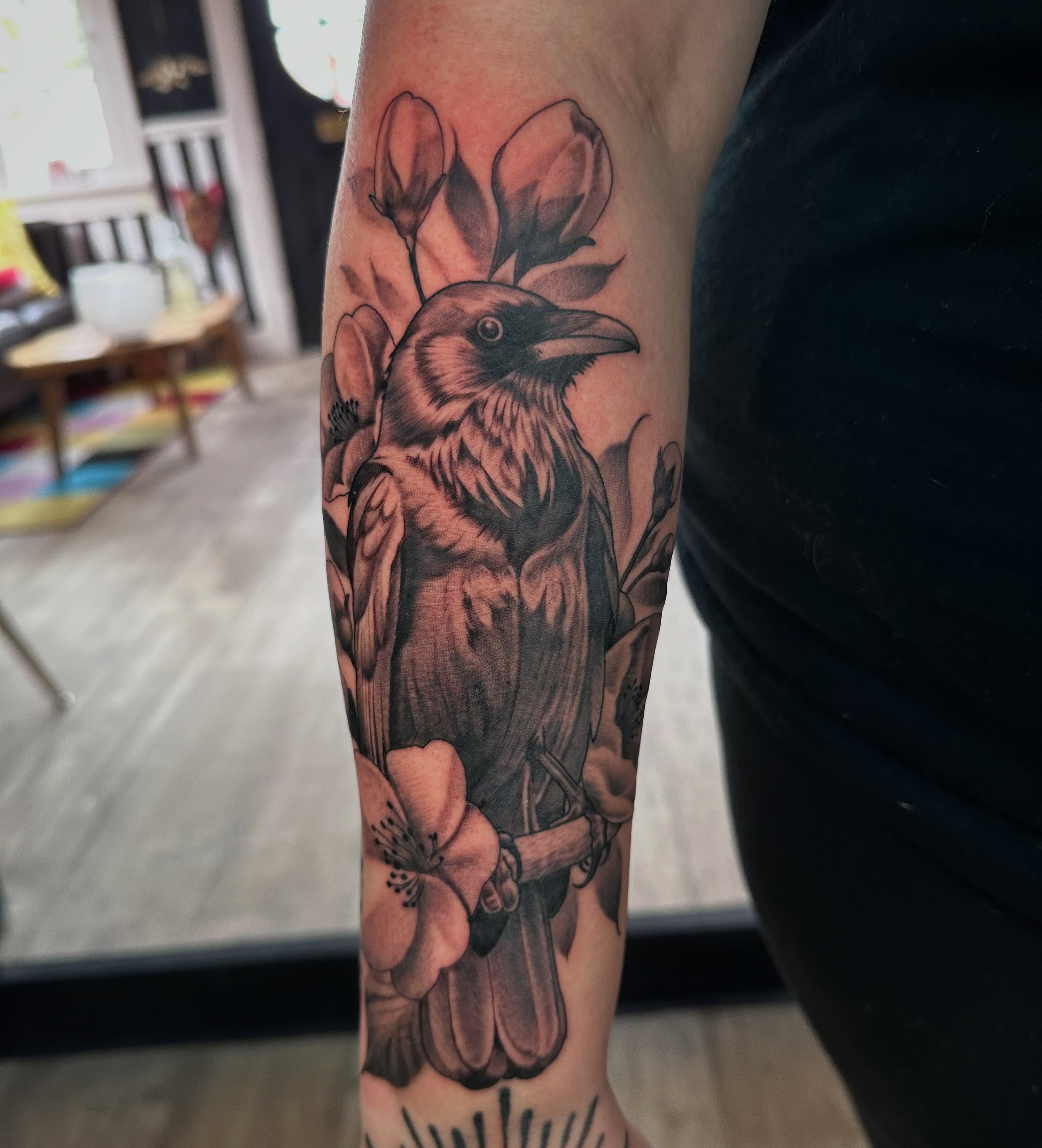 Crow and blossoms realism tattoo on the forearm by Dustin Clark, Dayton, Ohio