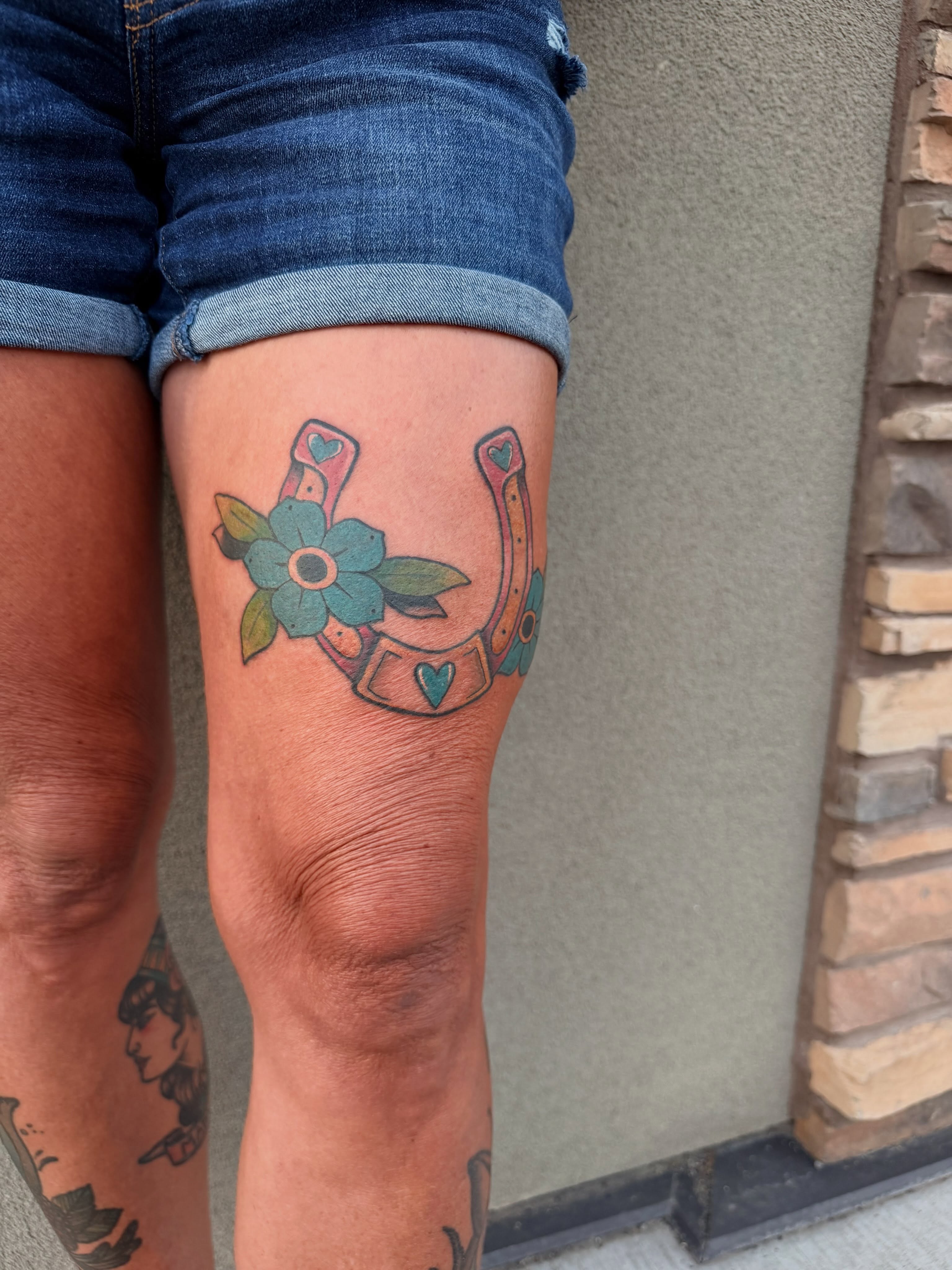 Horseshoe and flower American traditional tattoo on the thigh by Ellari