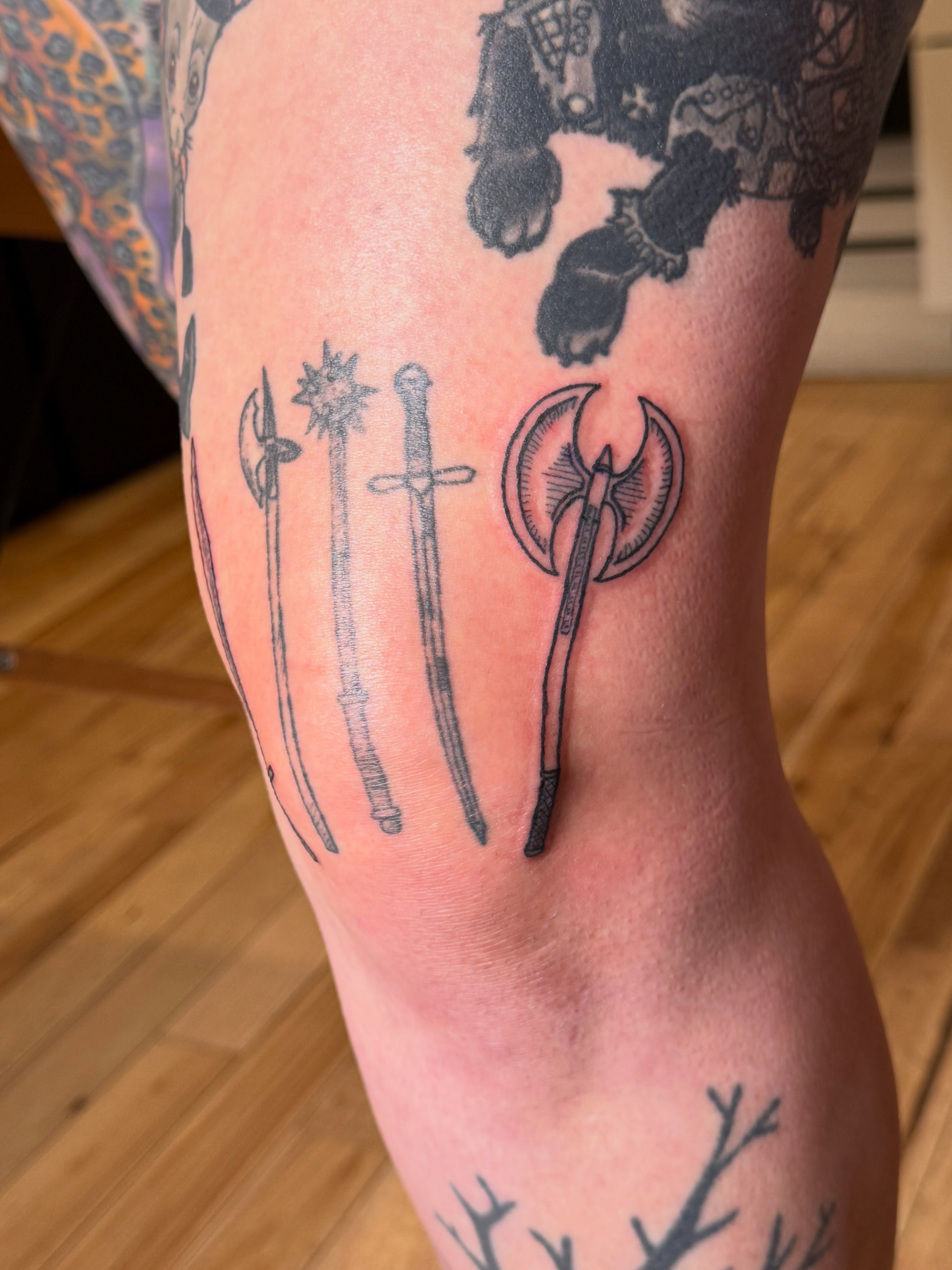 Medieval weapons black and grey tattoo on the leg by Eric Guntor, Philadelphia, Pennsylvania