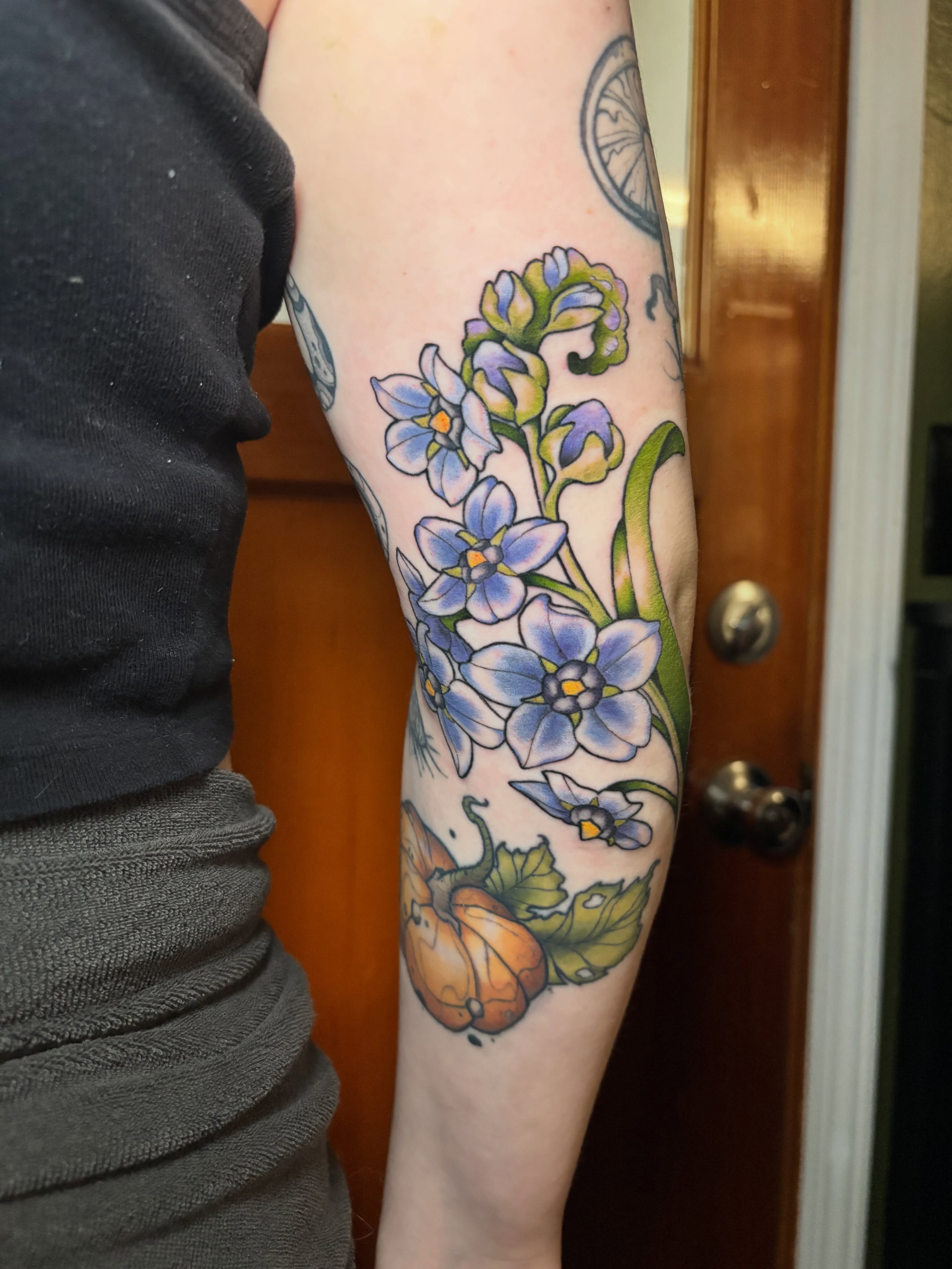 Blue flowers and pumpkins new school tattoo on the forearm by Wren Hollow, Portland, Oregon