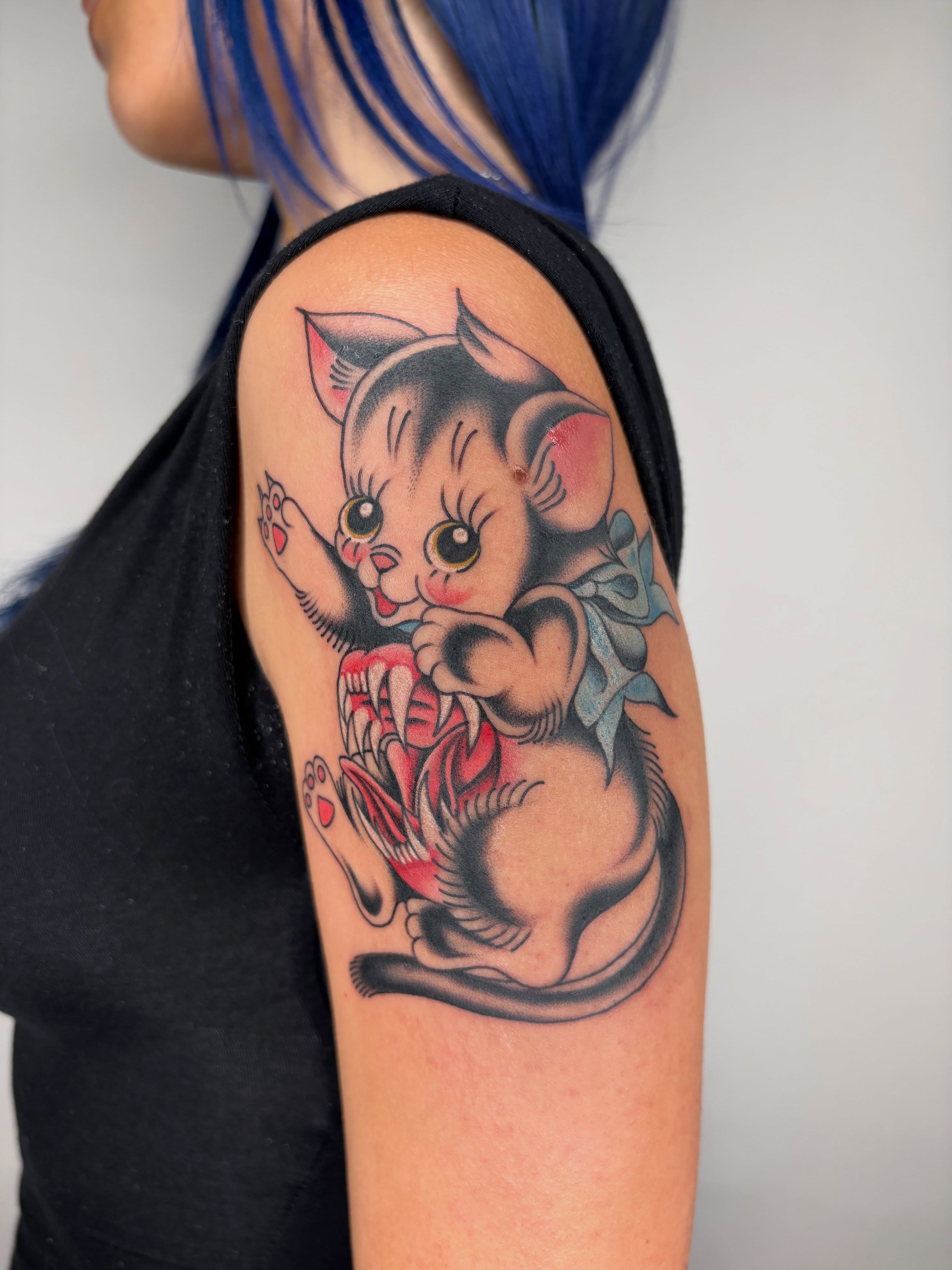 Cat American traditional tattoo on the upper arm by Nori