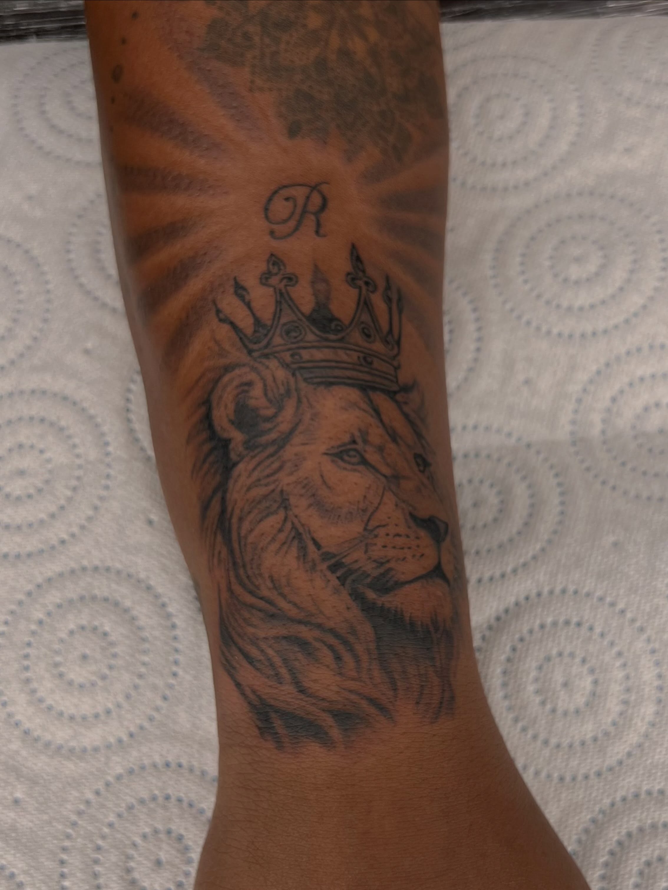 Lion with crown realism tattoo on the forearm by Tattoo (Réaliste), Toulouse, Occitanie