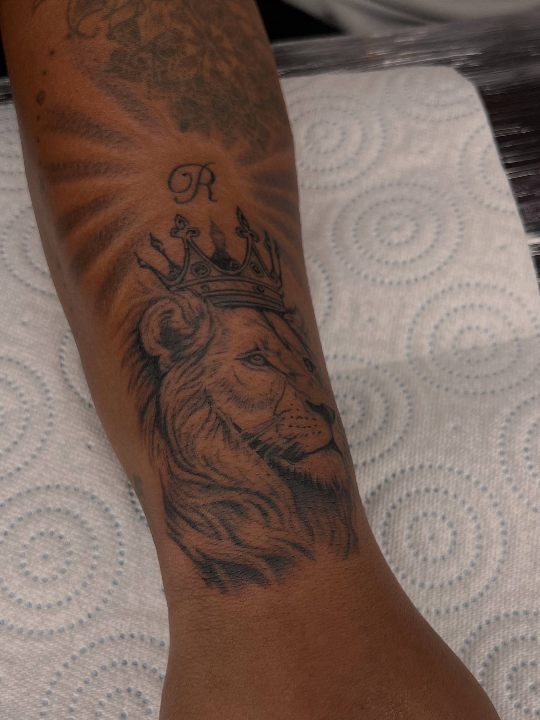 Lion with crown realism tattoo on the forearm by Tattoo (Réaliste), Toulouse, Occitanie