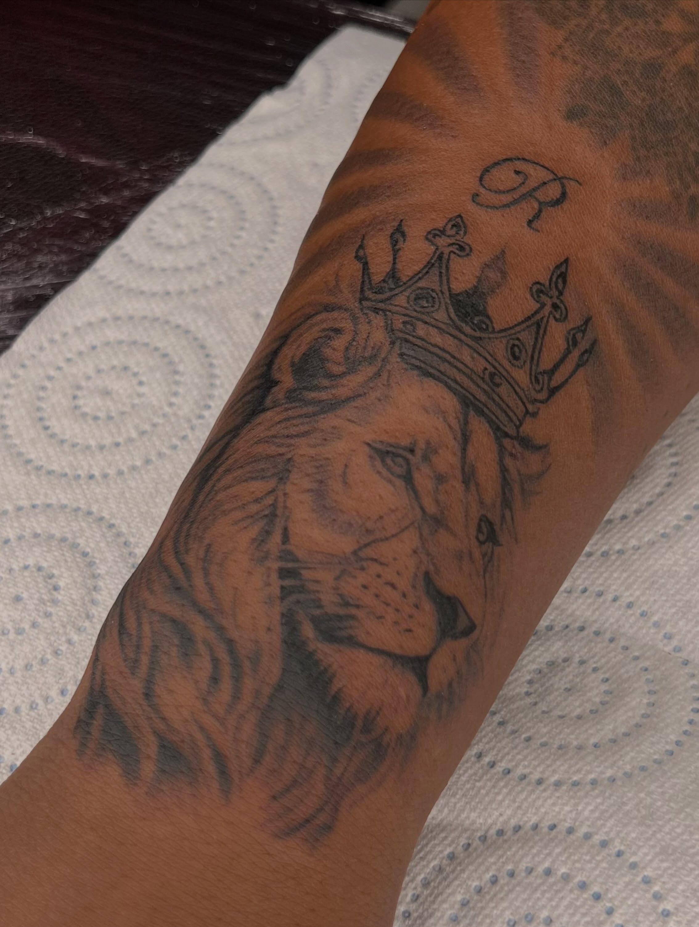 Lion with crown realism tattoo on the forearm by Tattoo (Réaliste), Toulouse, Occitanie