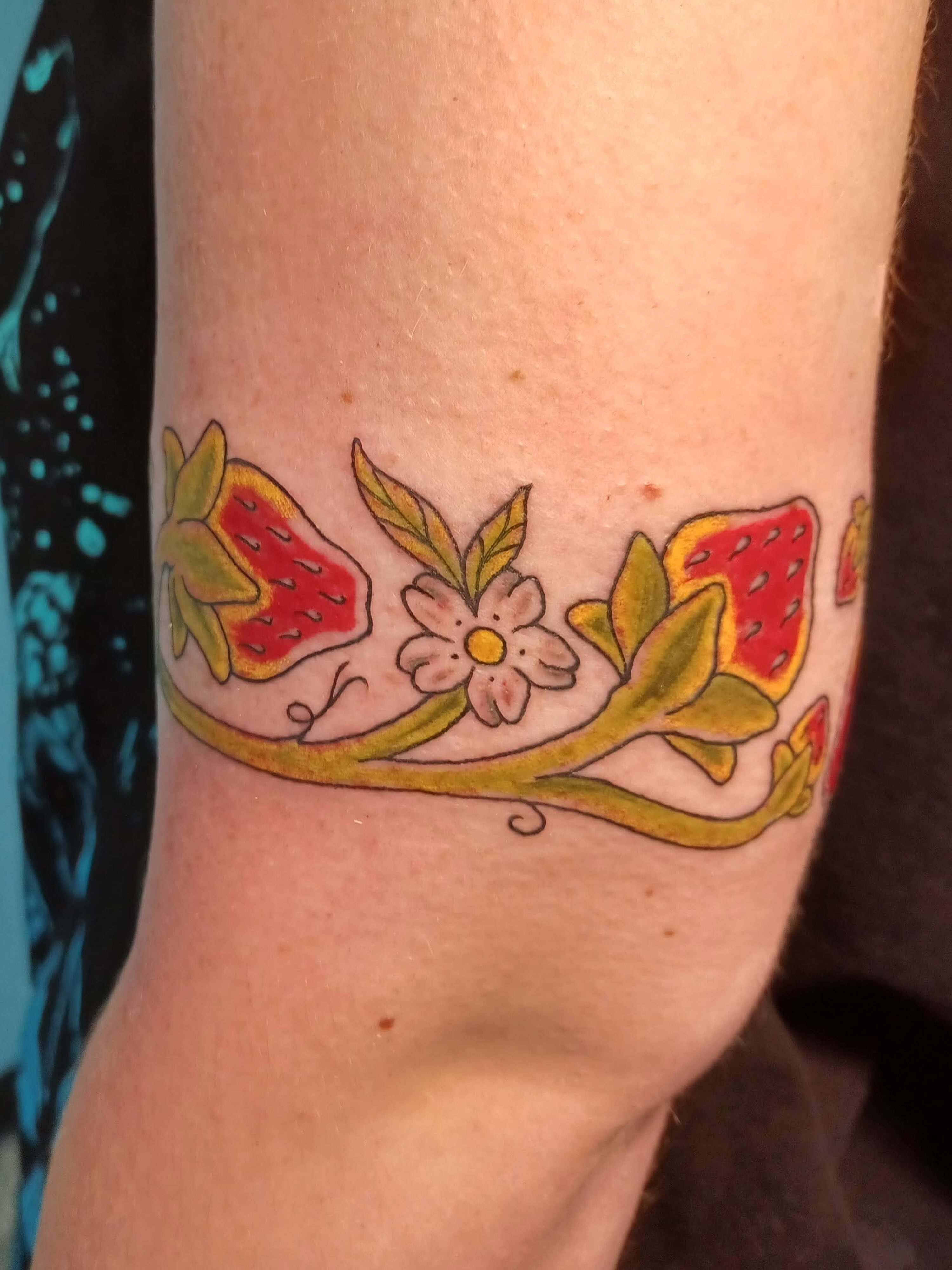 Strawberries and flowers new school tattoo on the forearm by Abi