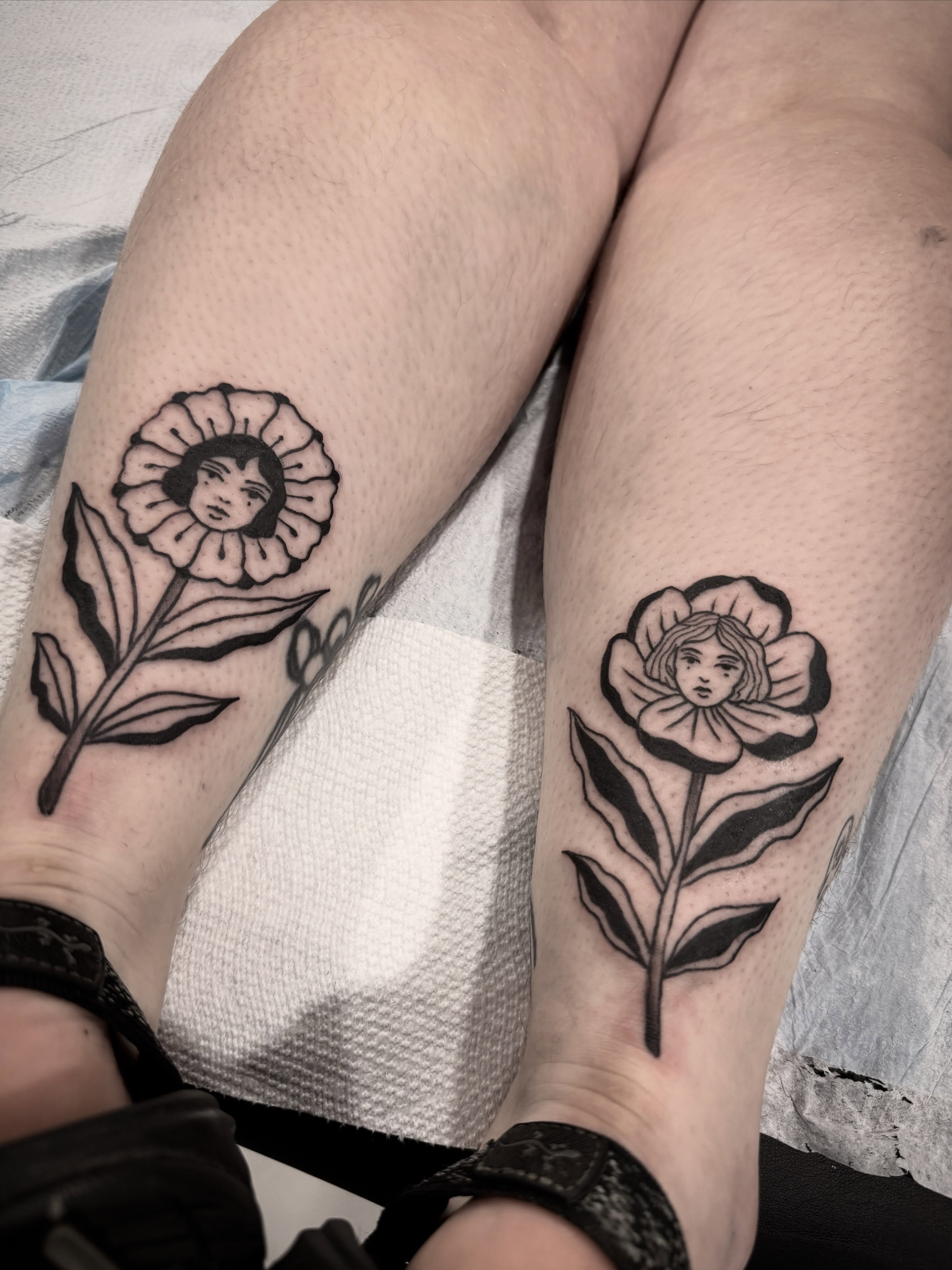 Flower with face black and grey tattoo on the leg by Shannon Misitano