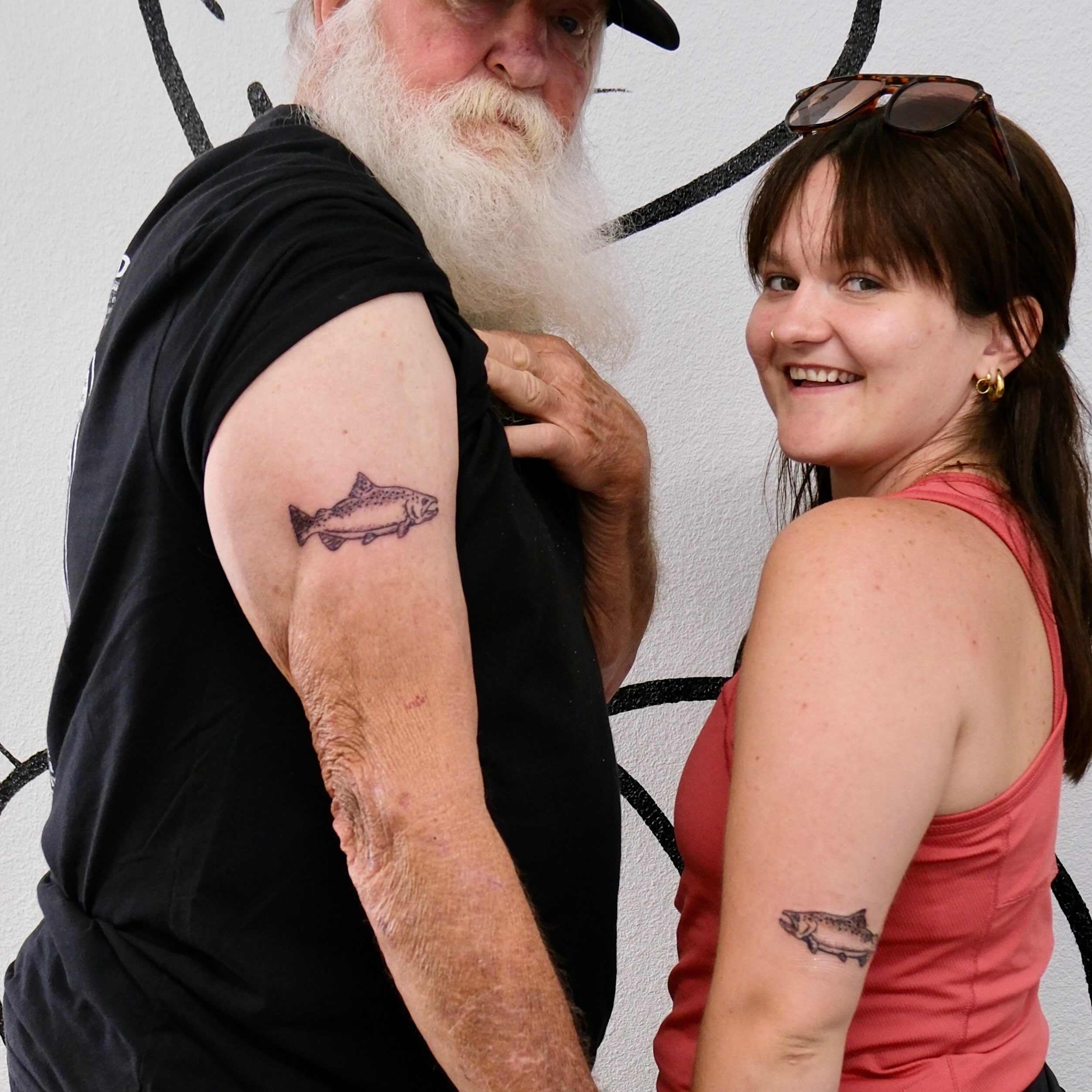 Salmon black and grey tattoo on the upper arm by Peggy