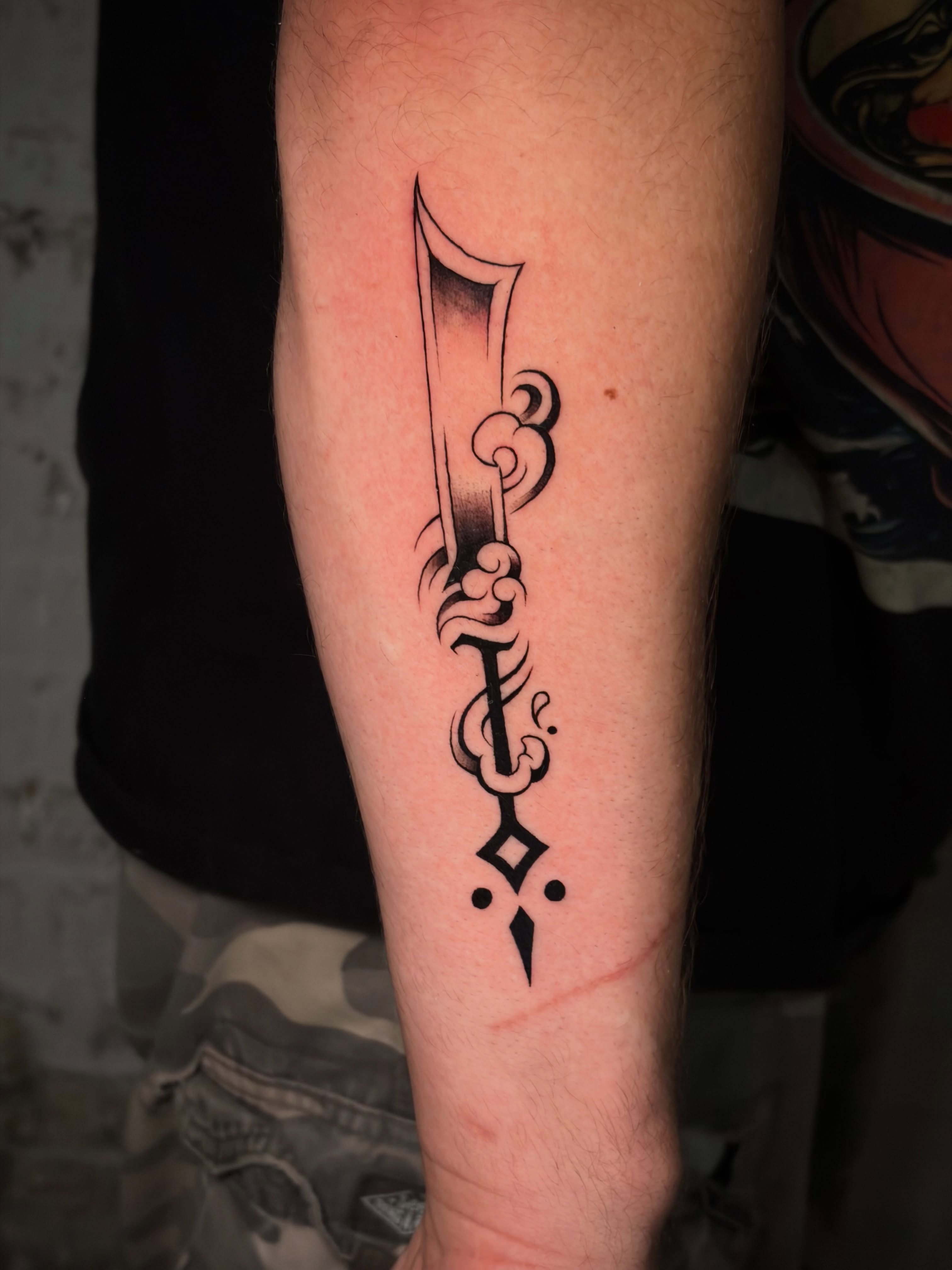 Sword and swirls black and grey tattoo on the forearm by Musa Selman