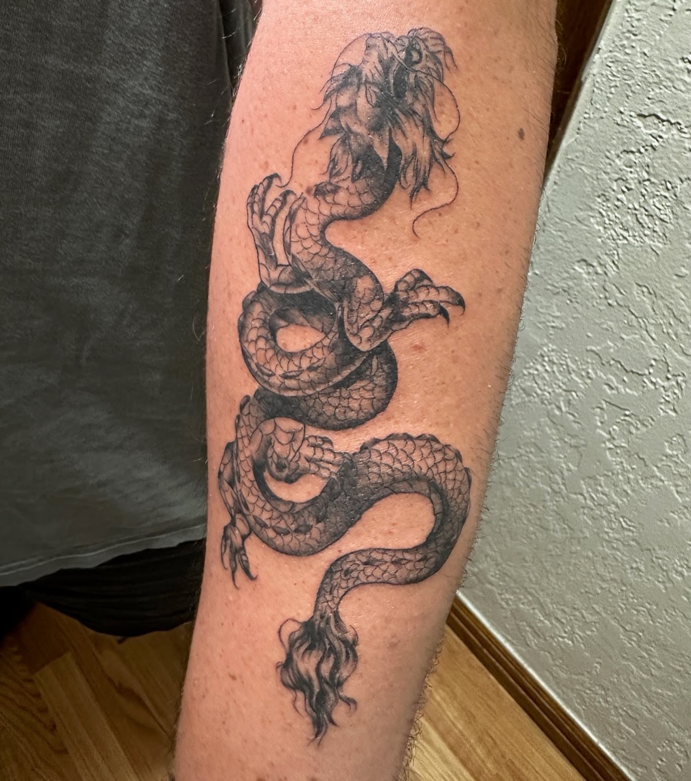 Dragon black and grey tattoo on the forearm by Mack ๐ Utah Tattoos