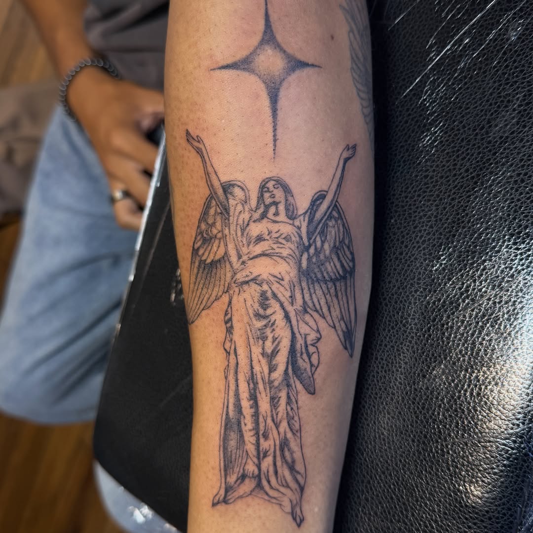 Angel with star black and grey tattoo on the forearm by Sienna (jj) Hicks
