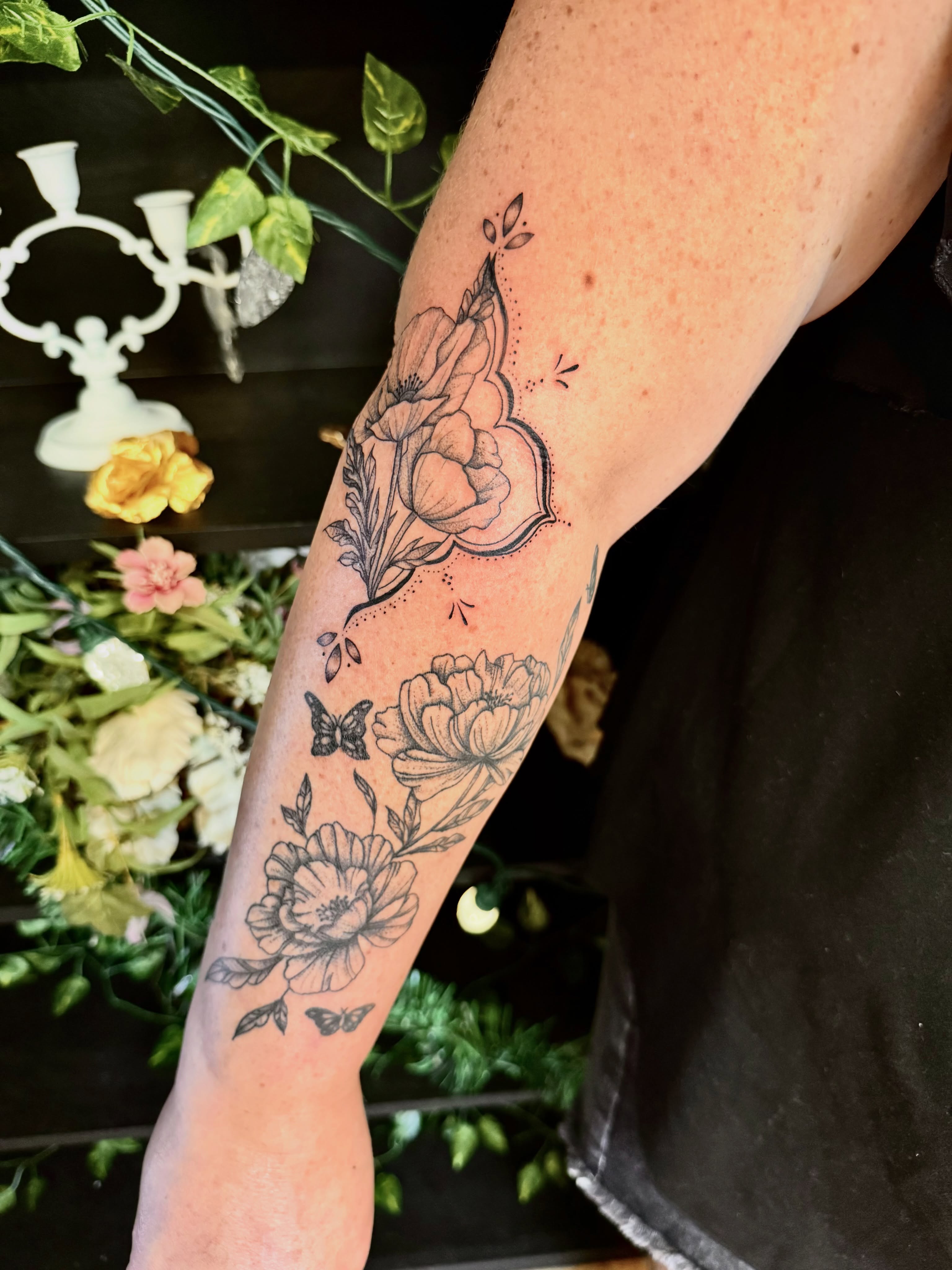 Floral bouquet black and grey tattoo on the forearm by Haley Bates