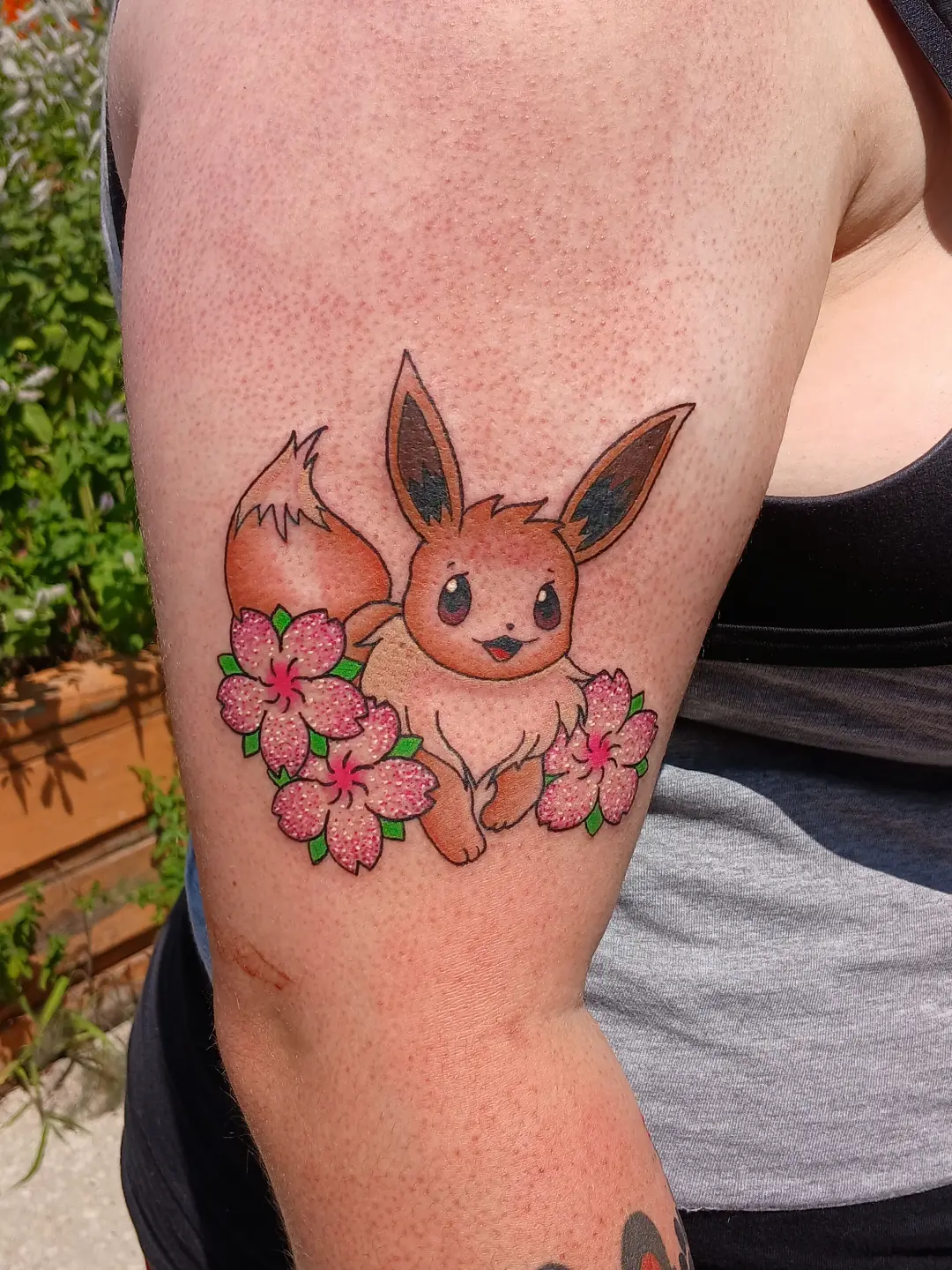 Eevee with cherry blossoms dotwork tattoo on the forearm by Amber Tattoos