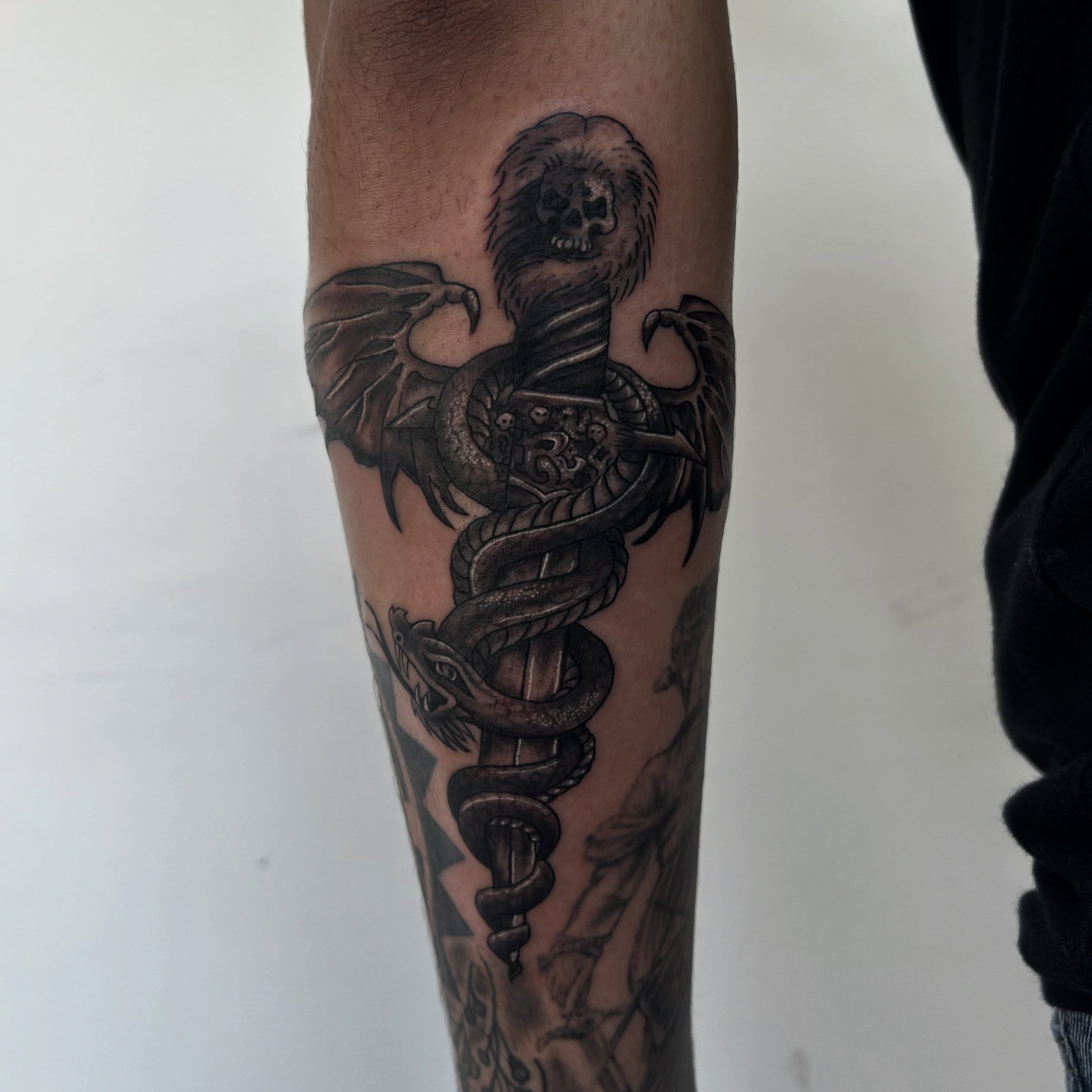 Caduceus black and grey tattoo on the forearm by Tawni Bender