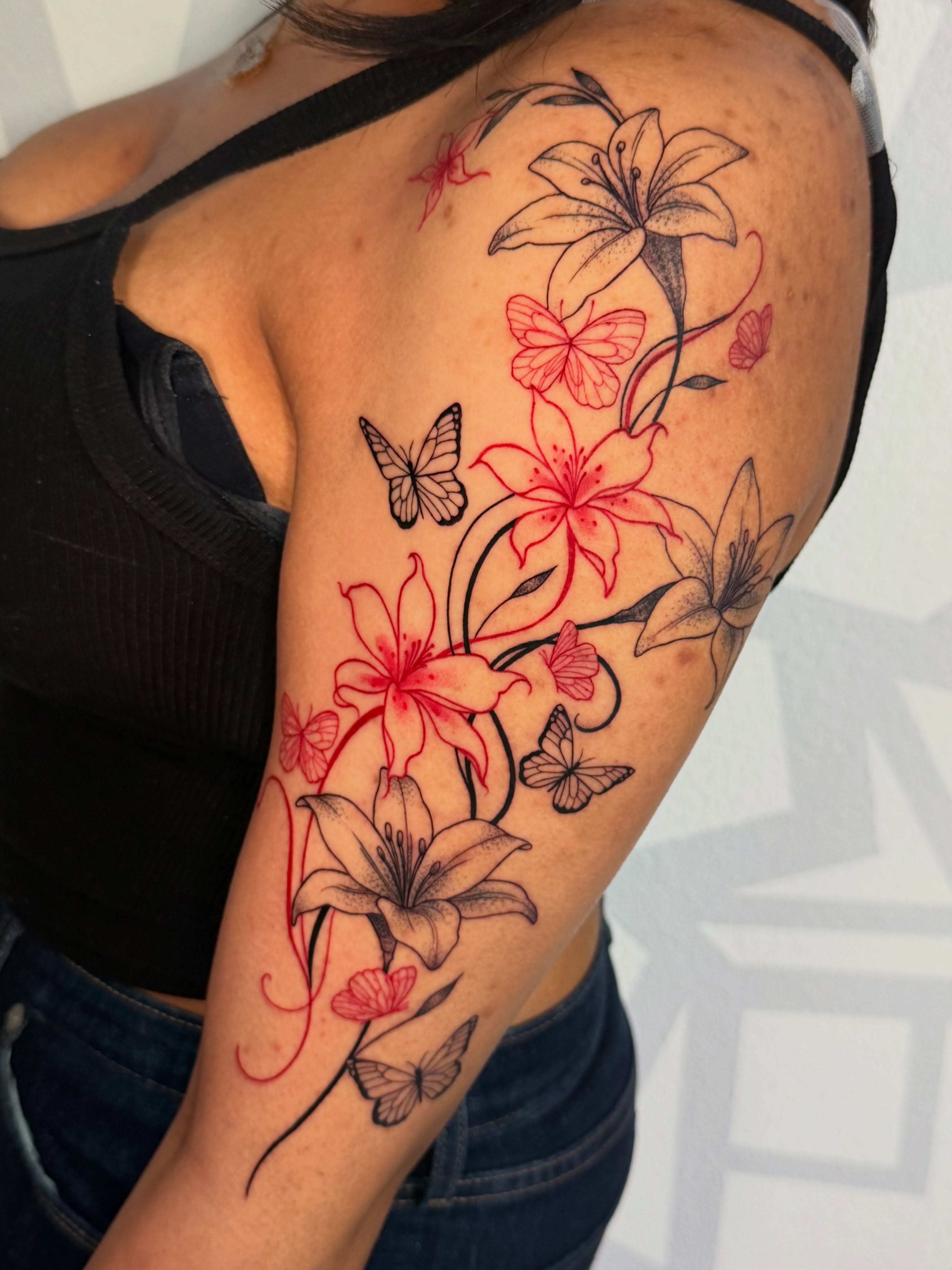 Lilies and butterflies new school tattoo on the upper arm by Las Vegas Tattoo Artist, Las Vegas, Nevada
