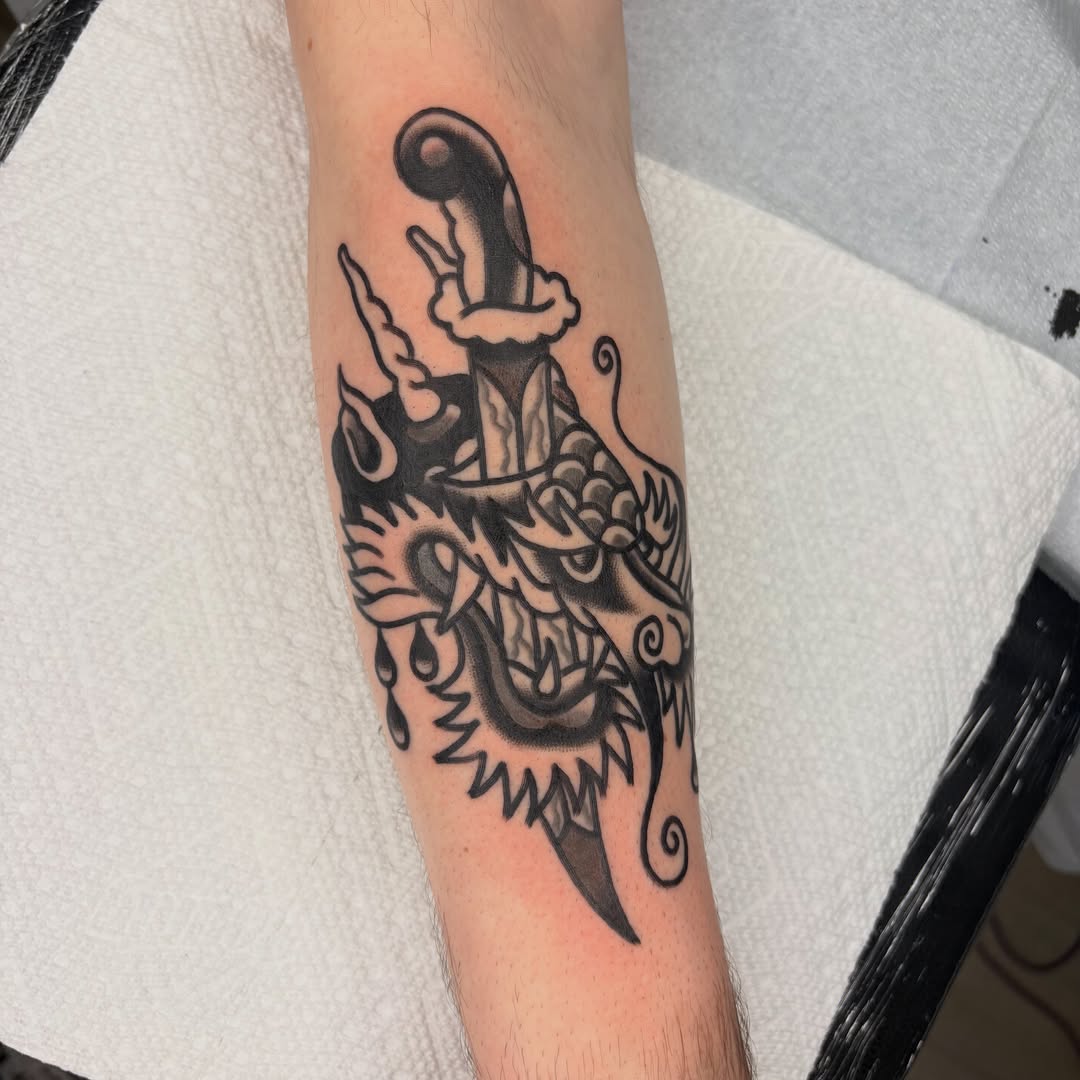 Dragon and sword black and grey tattoo on the forearm by Braedon 🎱