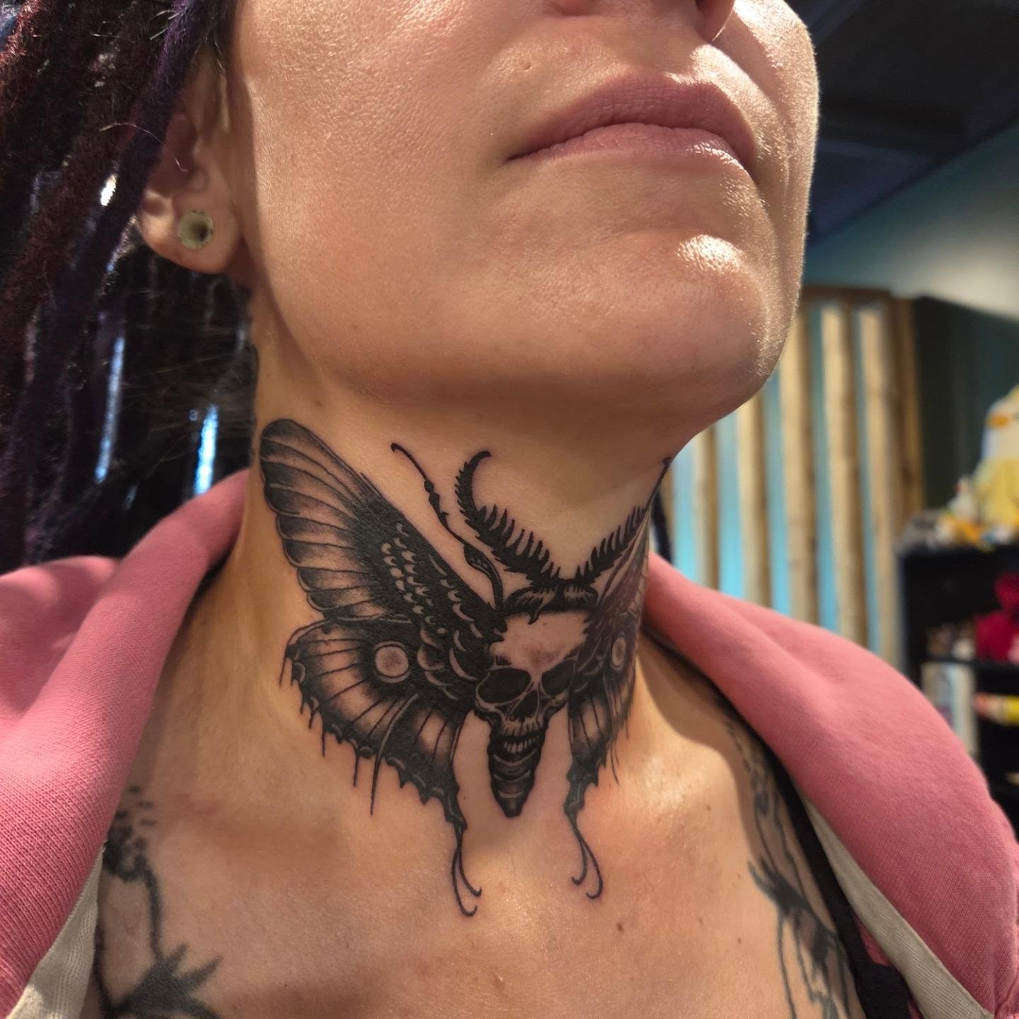 Butterfly skull dark realism tattoo on the neck by Nicole Bett