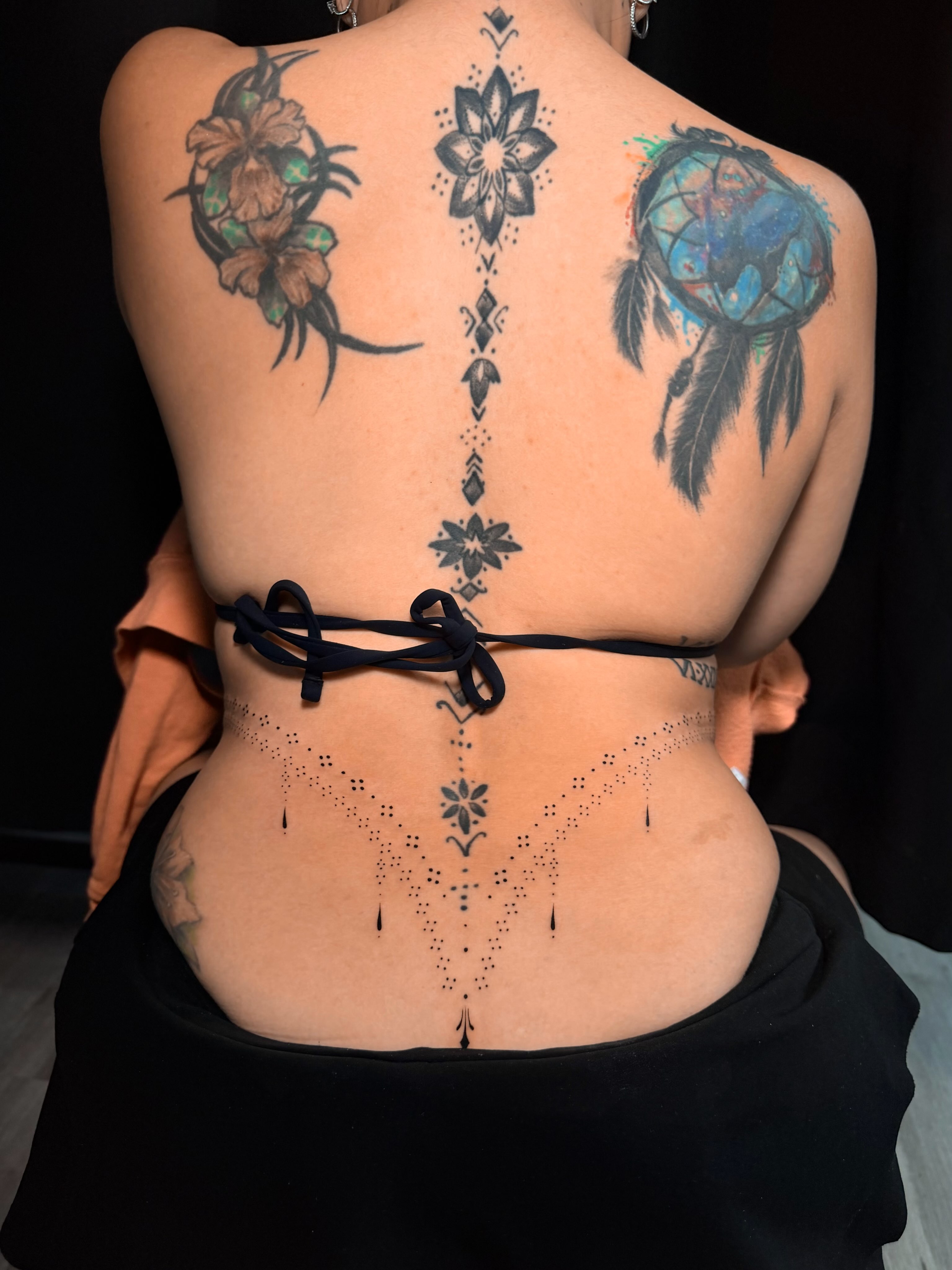 Floral and dreamcatcher dotwork tattoo on the back by Frida Tattooista