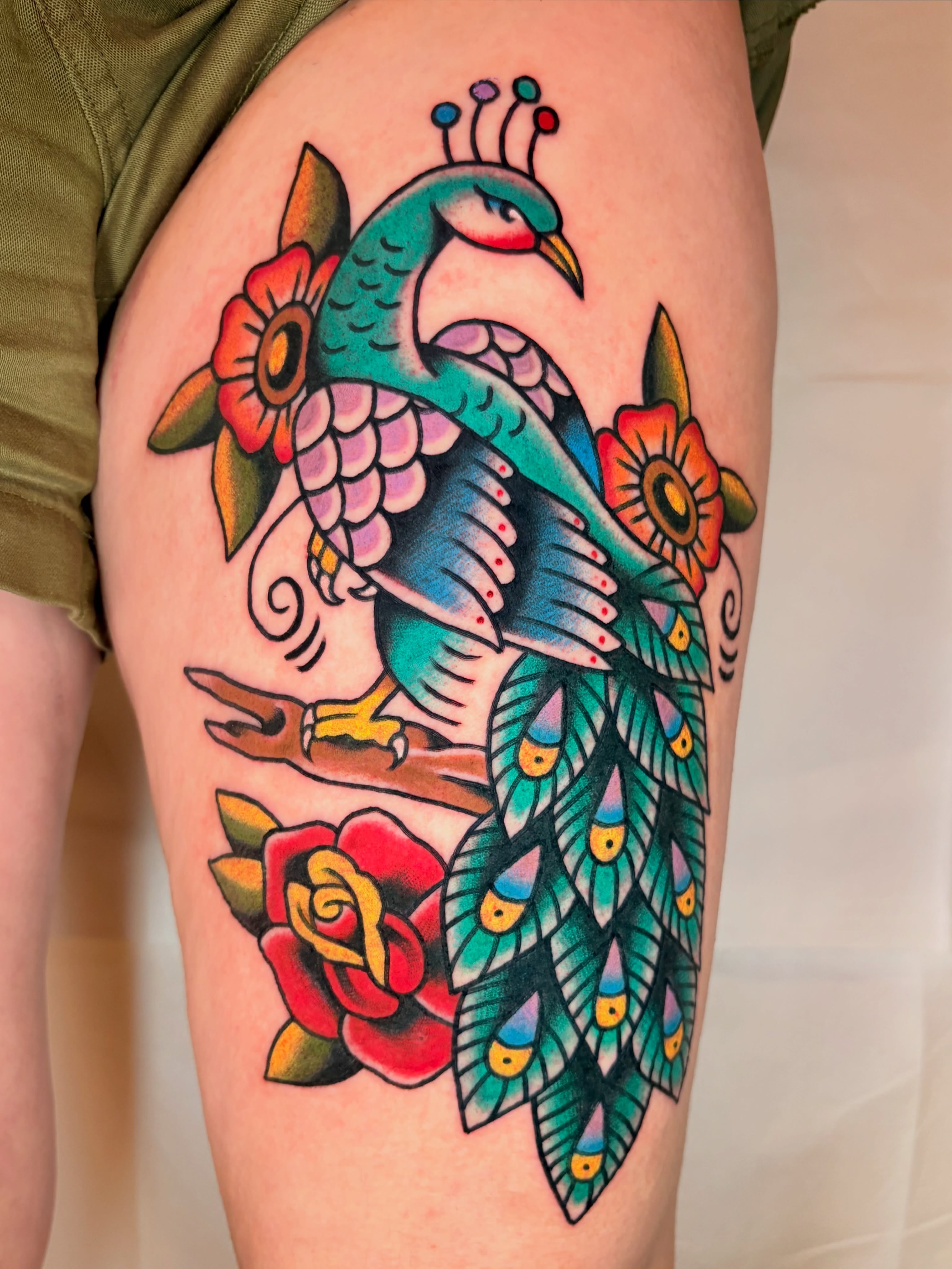 Peacock and flowers American traditional tattoo on the thigh by ๐ต๐๐๐๐ ๐ฎ๐๐๐๐๐๐, New Orleans, Louisiana