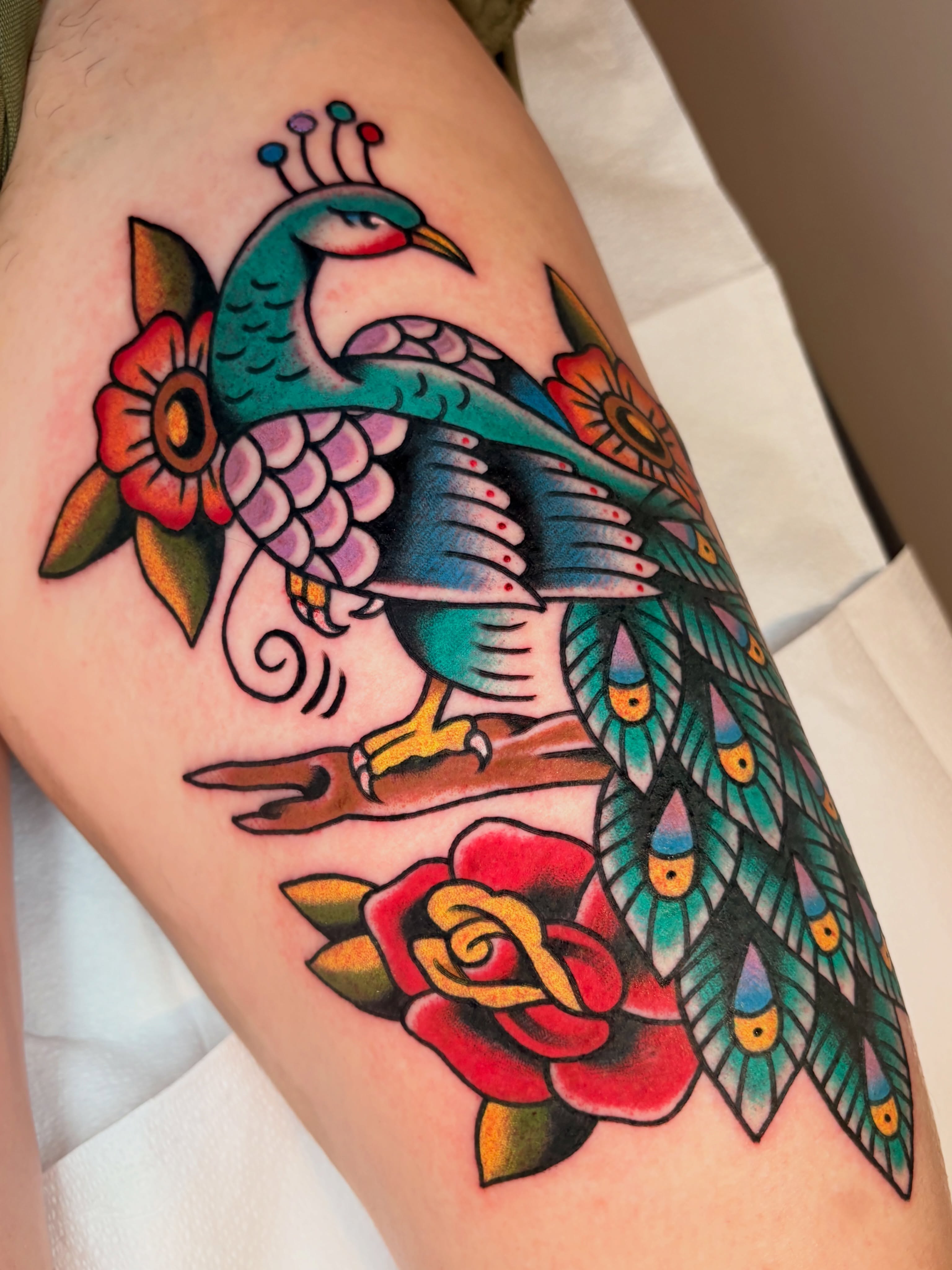 Peacock and rose American traditional tattoo on the thigh by ๐ต๐๐๐๐ ๐ฎ๐๐๐๐๐๐, New Orleans, Louisiana