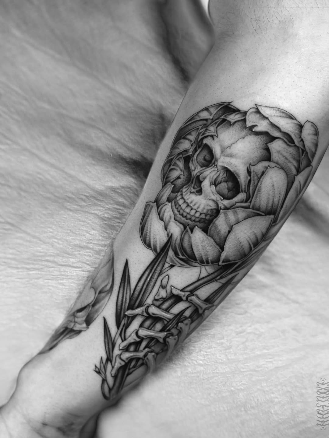 Skull in flower with skeleton hand realism tattoo on the forearm by Steve Franciosa
