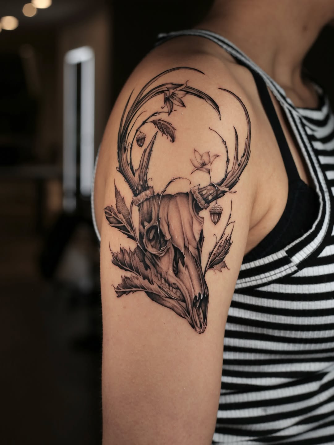 Deer skull with flowers and acorns realism tattoo on the shoulder by Steve Franciosa