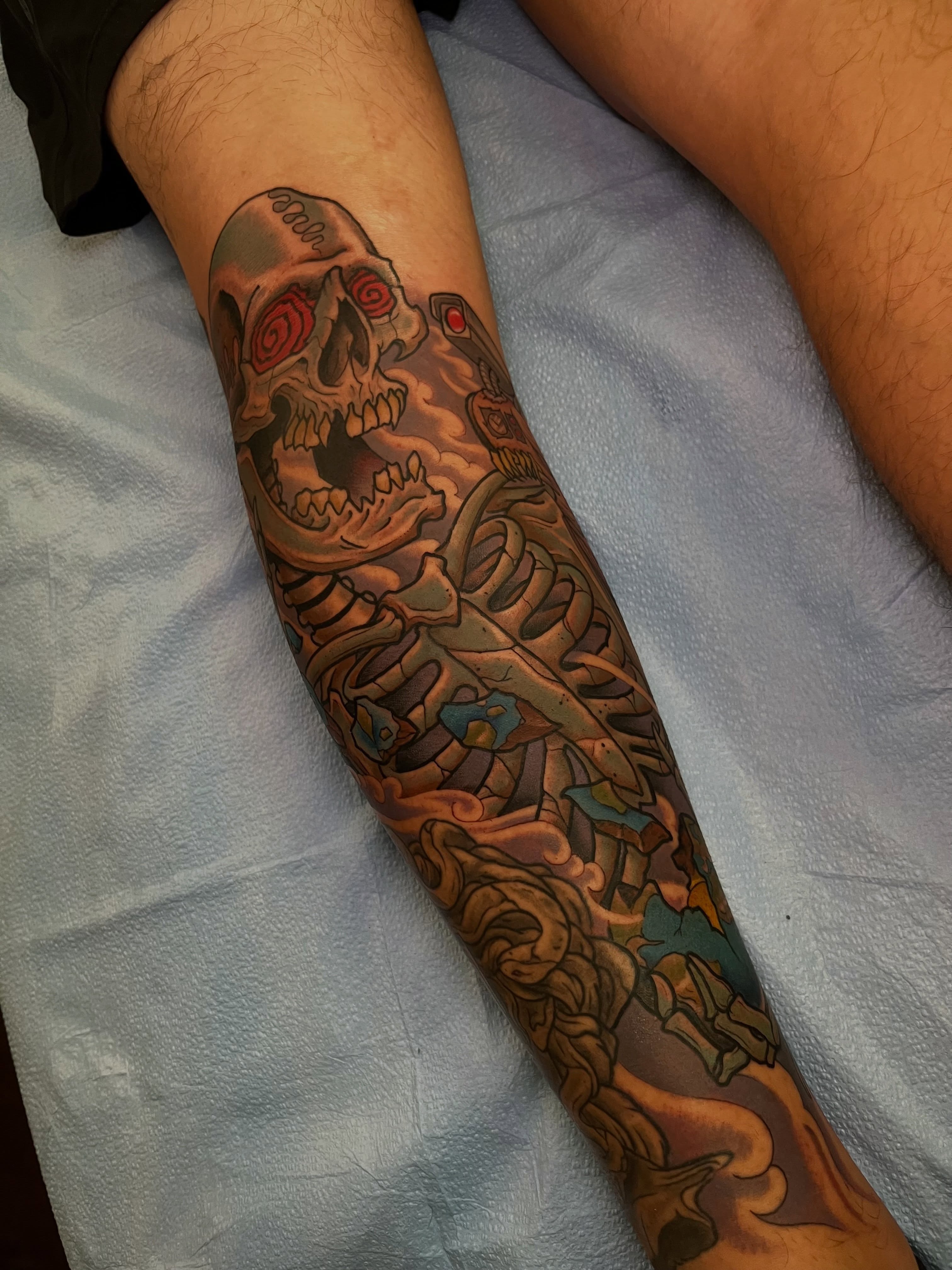 Skull and mechanical elements neo-traditional tattoo on the forearm by Evan Perrine