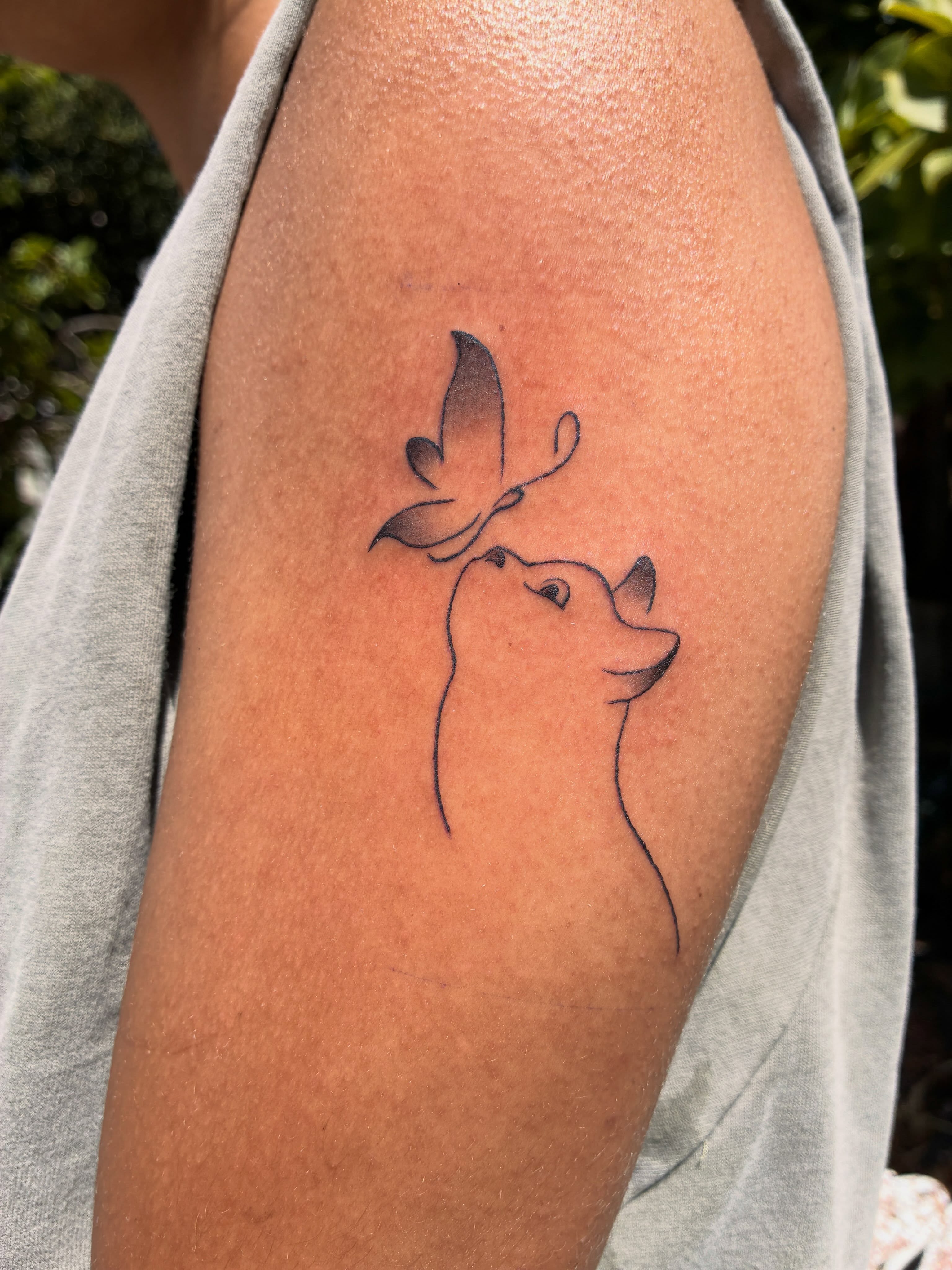 Dog and butterfly minimalist tattoo on the forearm by Xin.H