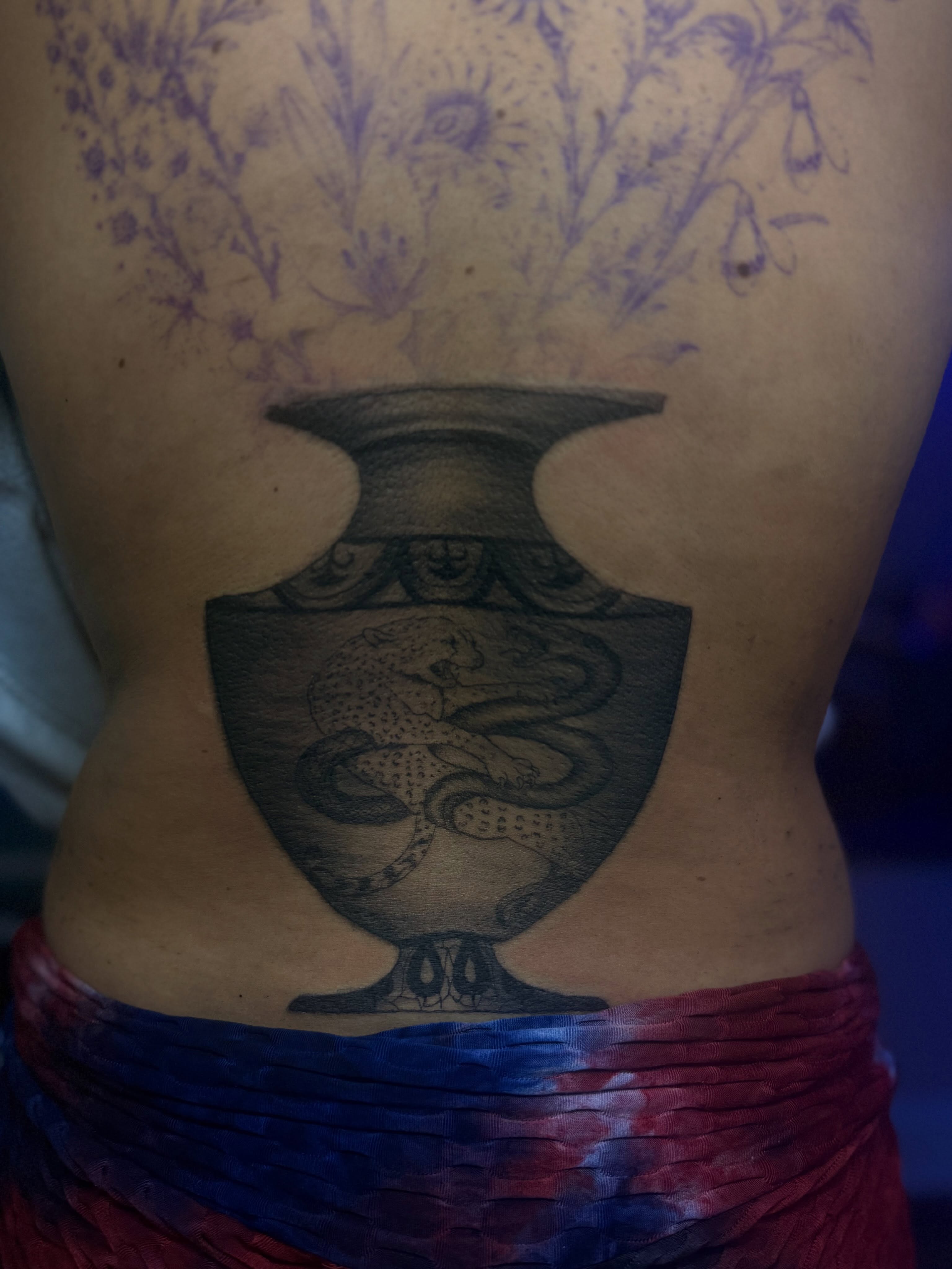 Serpent and shield black and grey tattoo on the torso by Tattoos by Santos