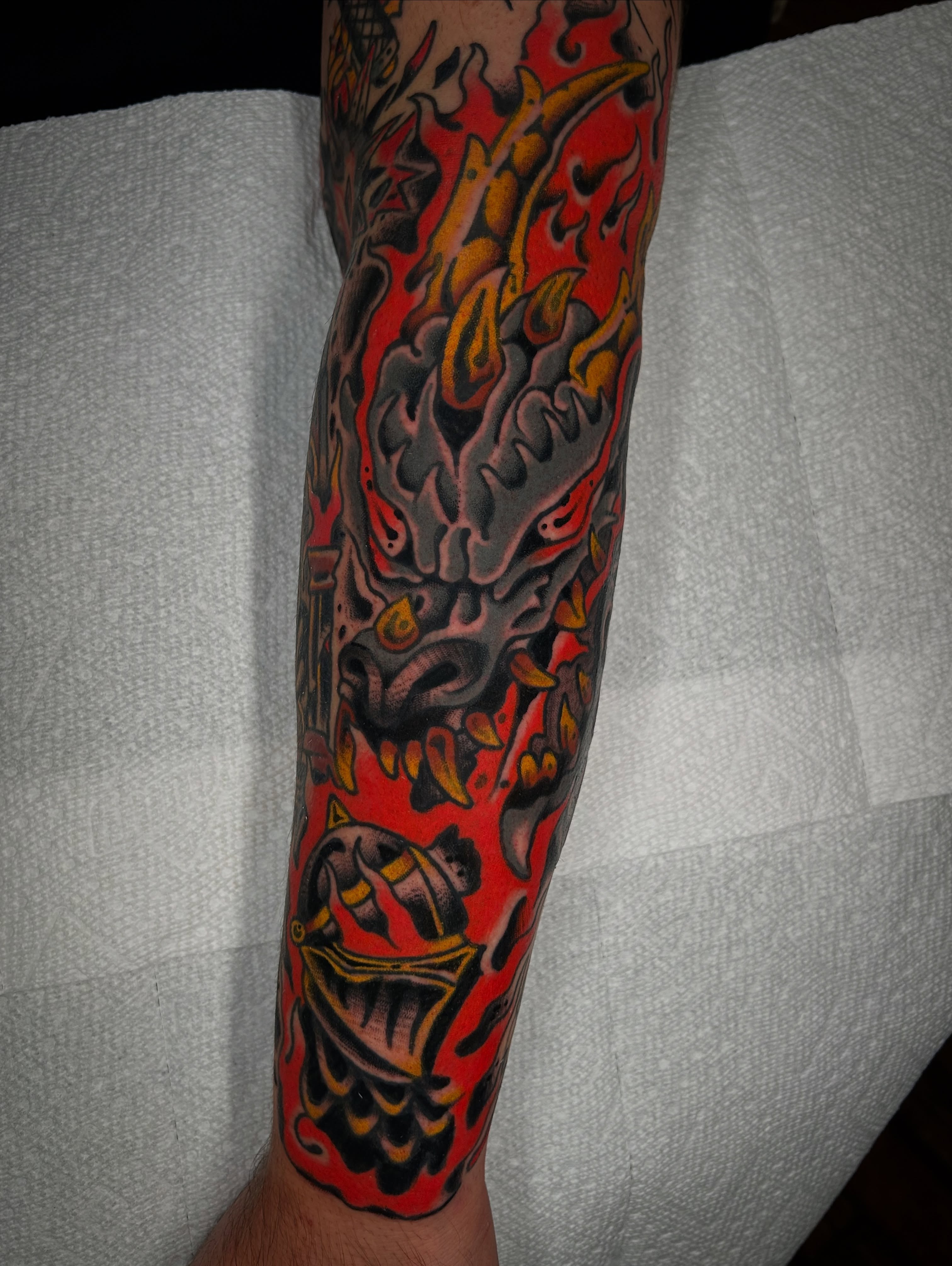 Flaming dragon American traditional tattoo on the forearm by Kit Miller, Indianapolis, Indiana
