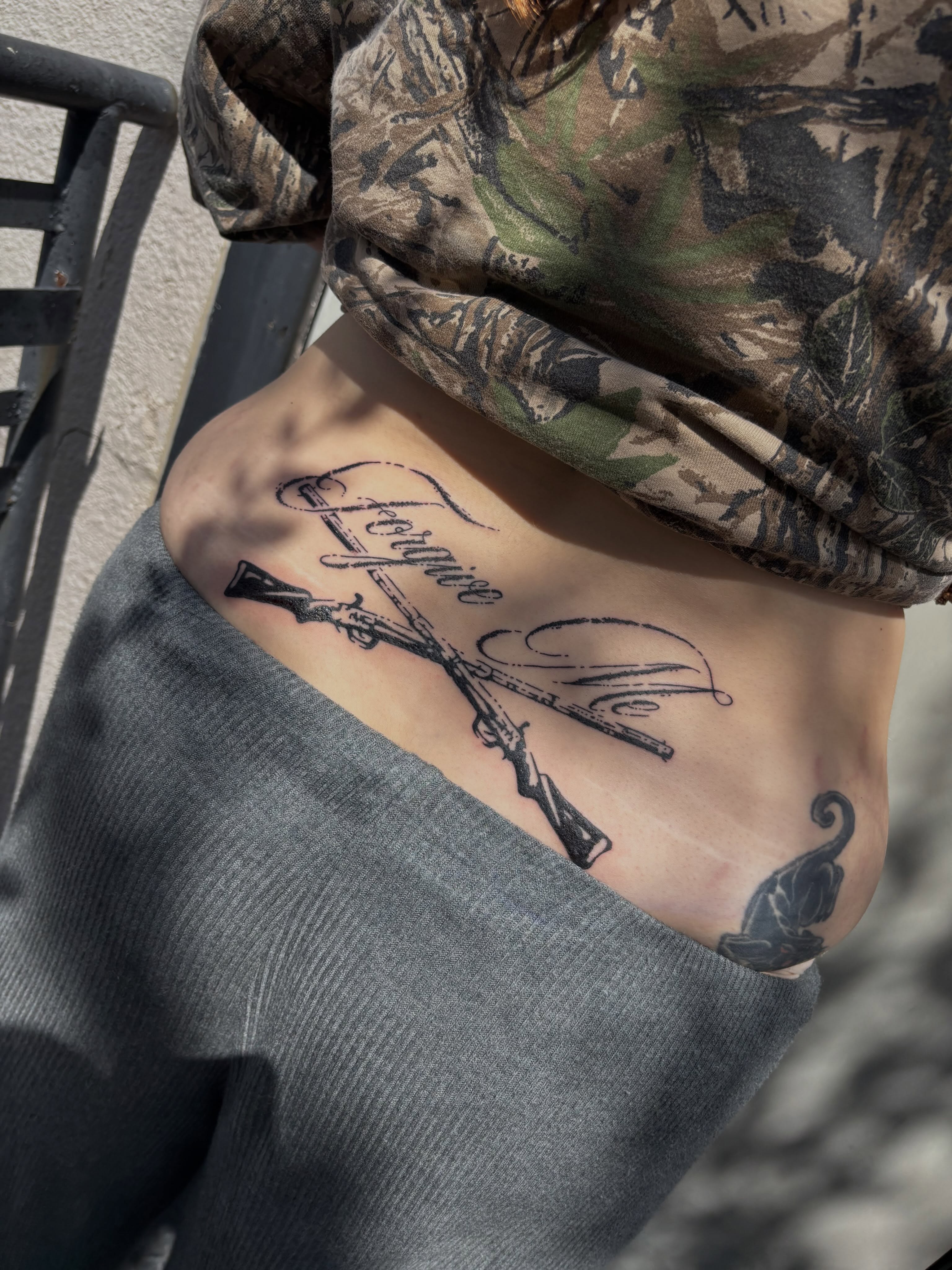 Crossed rifles and script black and grey tattoo on the ribs by Turner