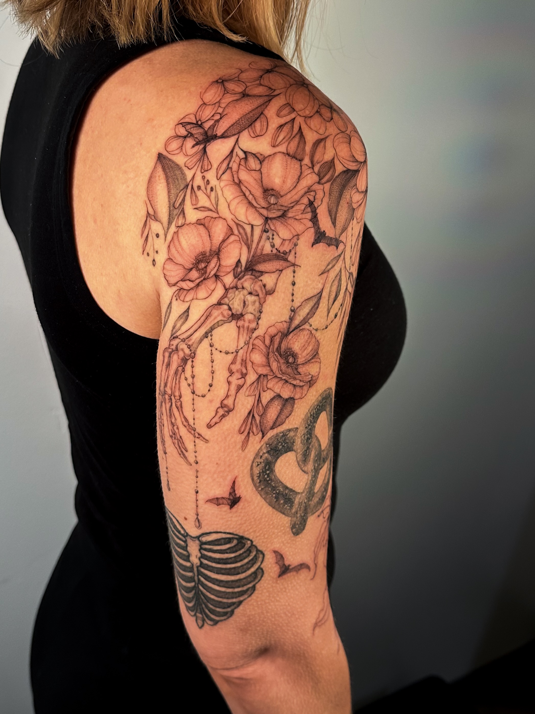 Floral bouquet realism tattoo on the upper arm by Caroline + Utah Tattoo Artist