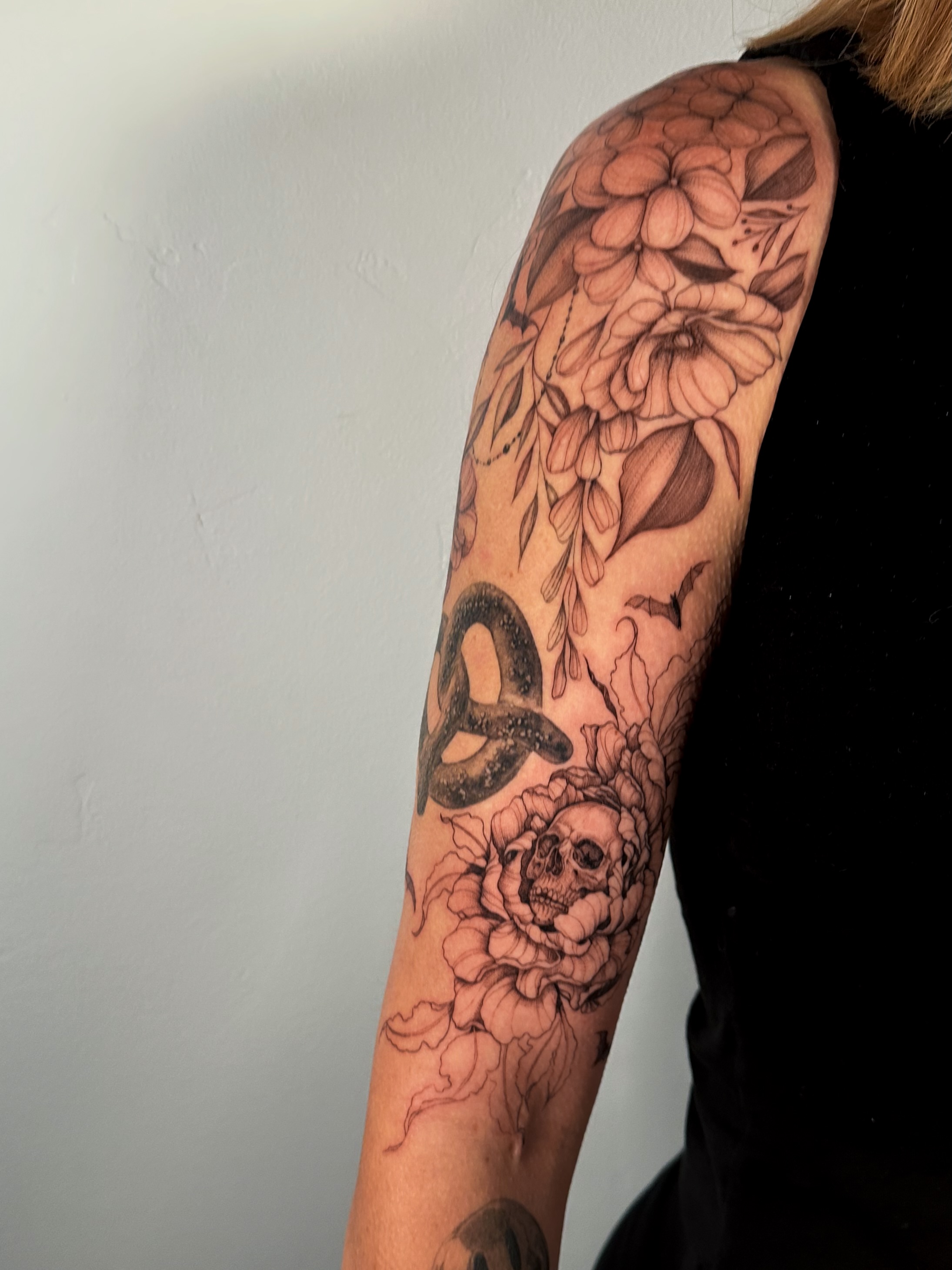 Peony and skull realism tattoo on the forearm by Caroline + Utah Tattoo Artist