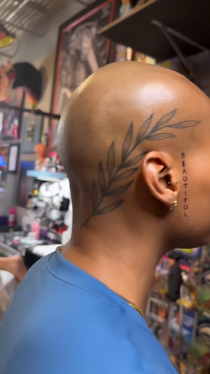 Laurel branch with script minimalist tattoo on the head by Michael Bogle