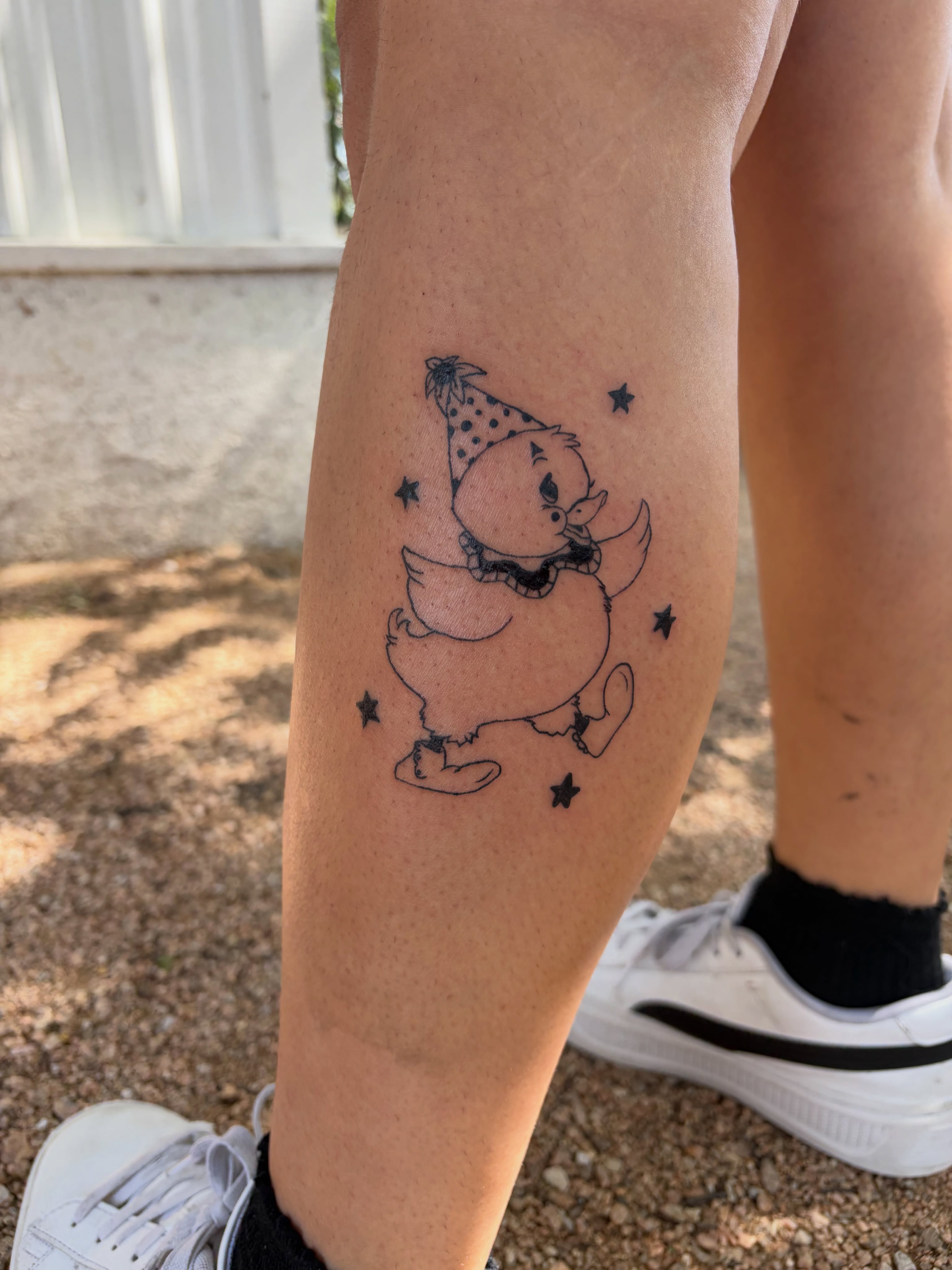 Chicken wearing party hat black and grey tattoo on the forearm by Inky Birdz Tattoos