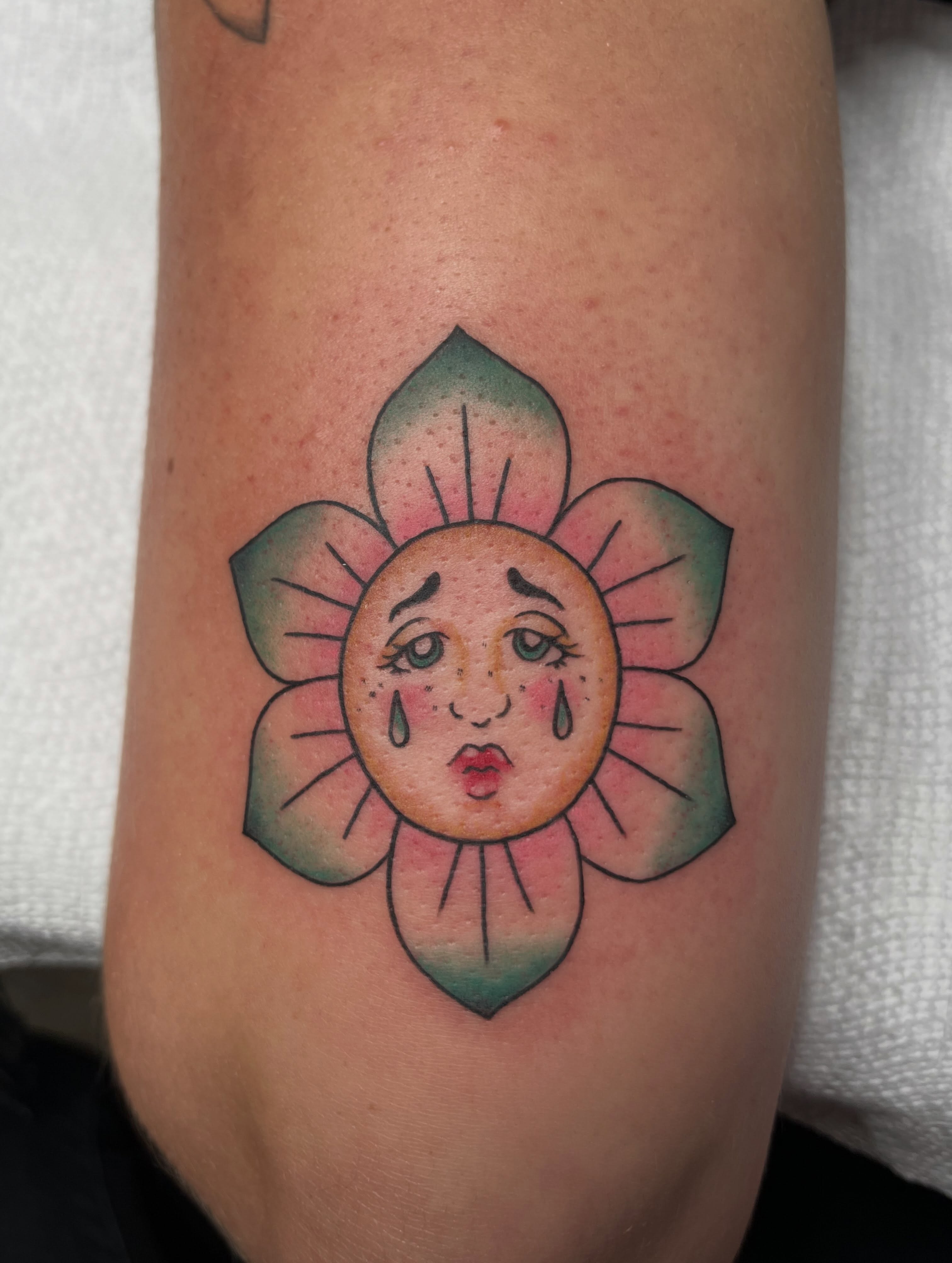 Sad sun American traditional tattoo on the forearm by Ty’s Tattoos