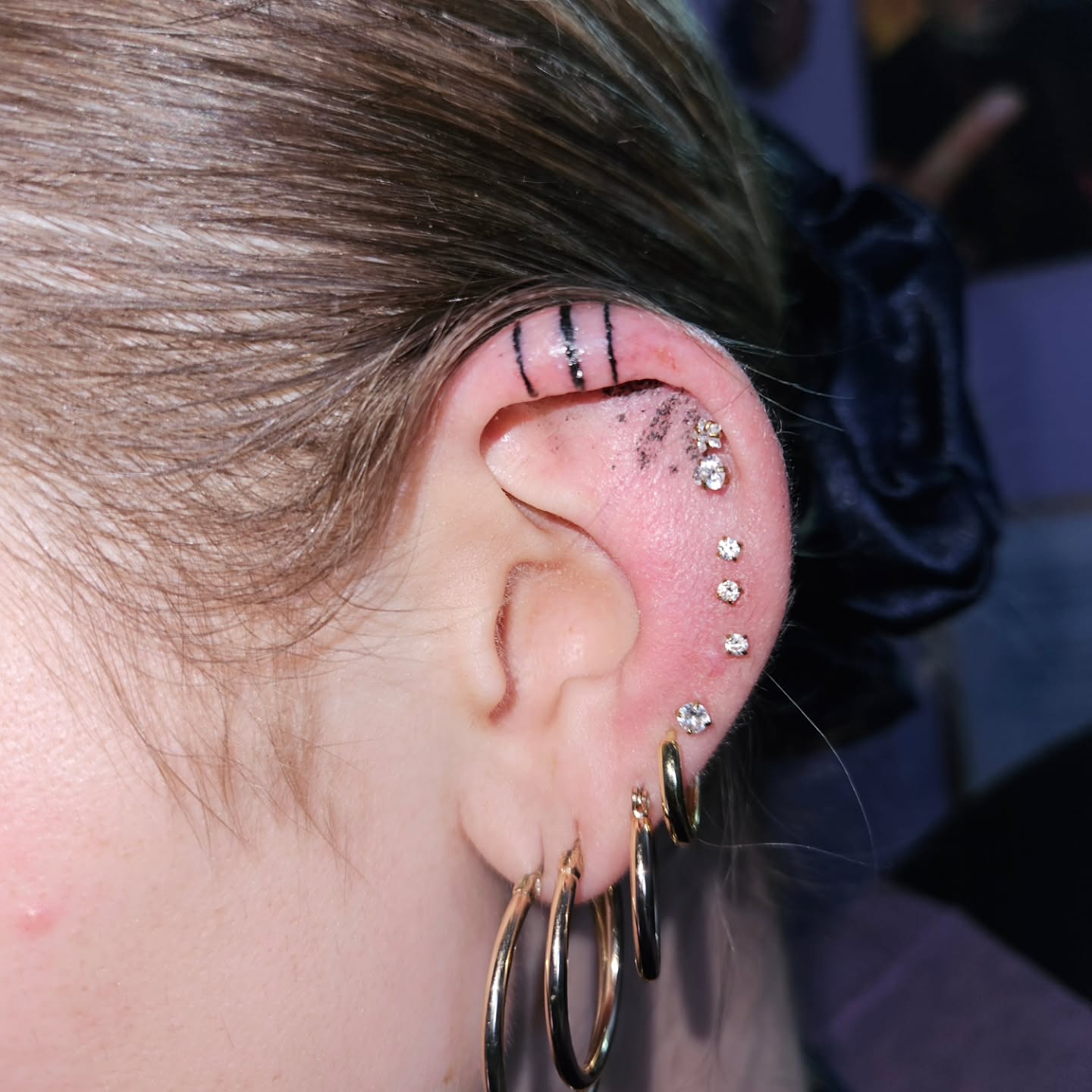 Ear piercing black and grey tattoo by Mischief π€