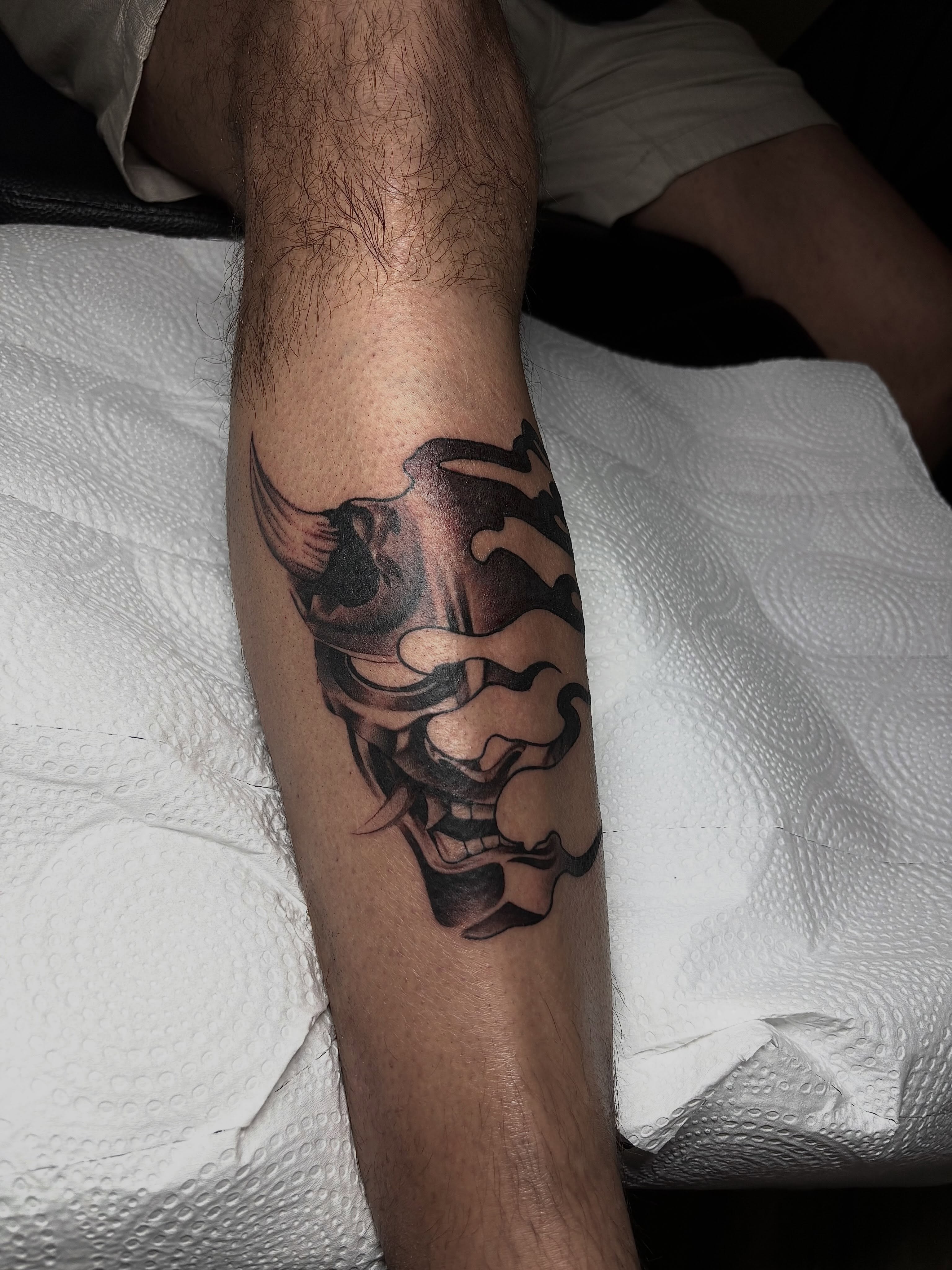 Mask black and grey tattoo on the forearm by Grace L