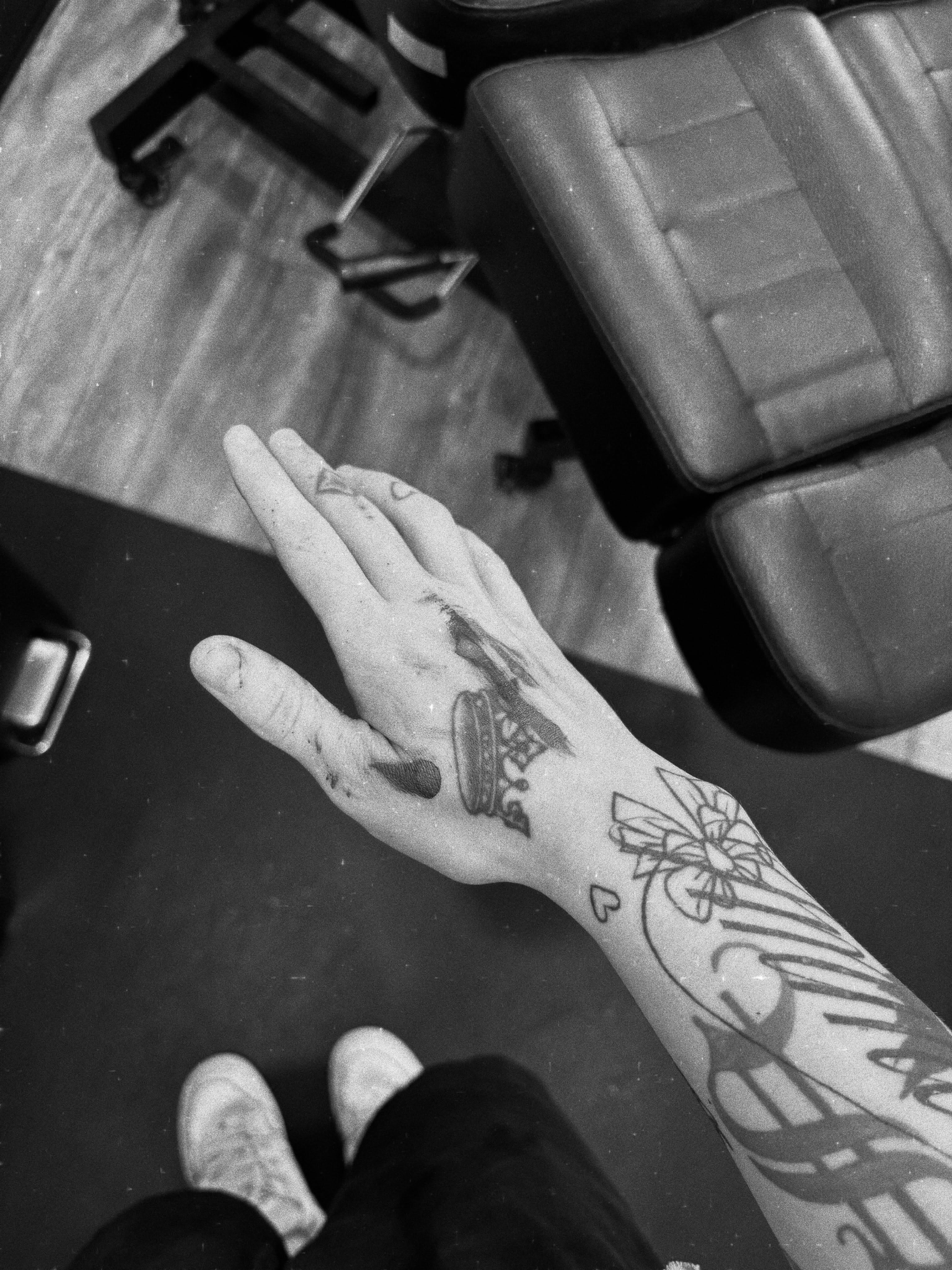 Ship and floral black and grey tattoo on the hand by Grace L