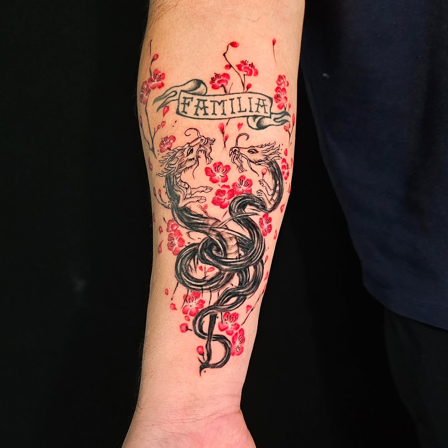 Snake and blossoms realism tattoo on the forearm by Lili Gu