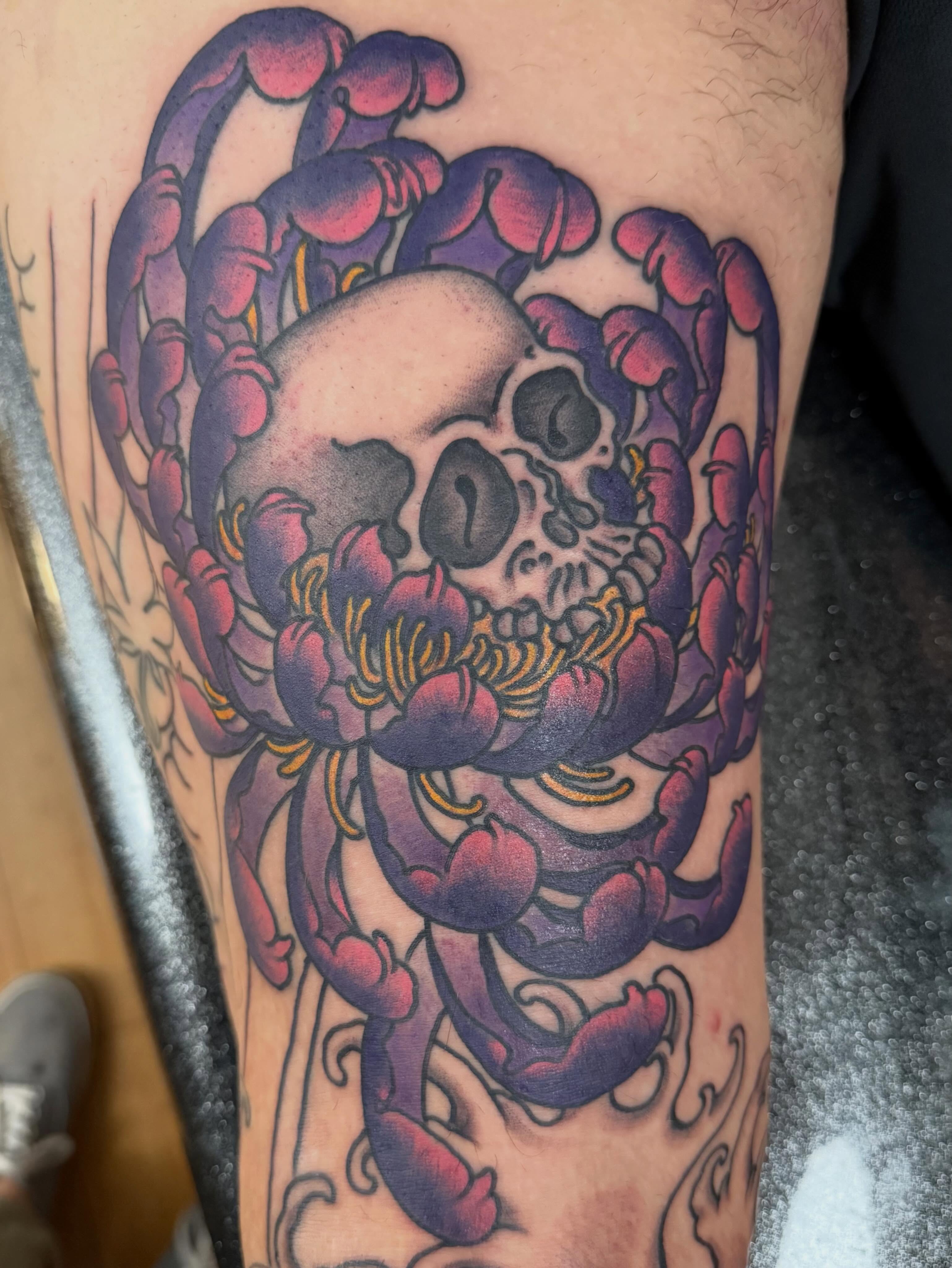 Skull and flowers American traditional tattoo on the forearm by Tony Beuke
