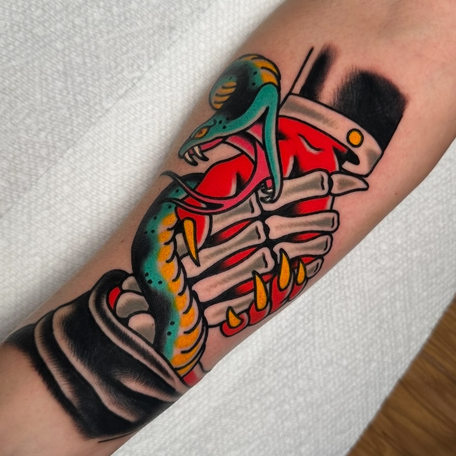 Snake and skeleton hand American traditional tattoo on the forearm by Schyler Ames, Canal Fulton, Ohio