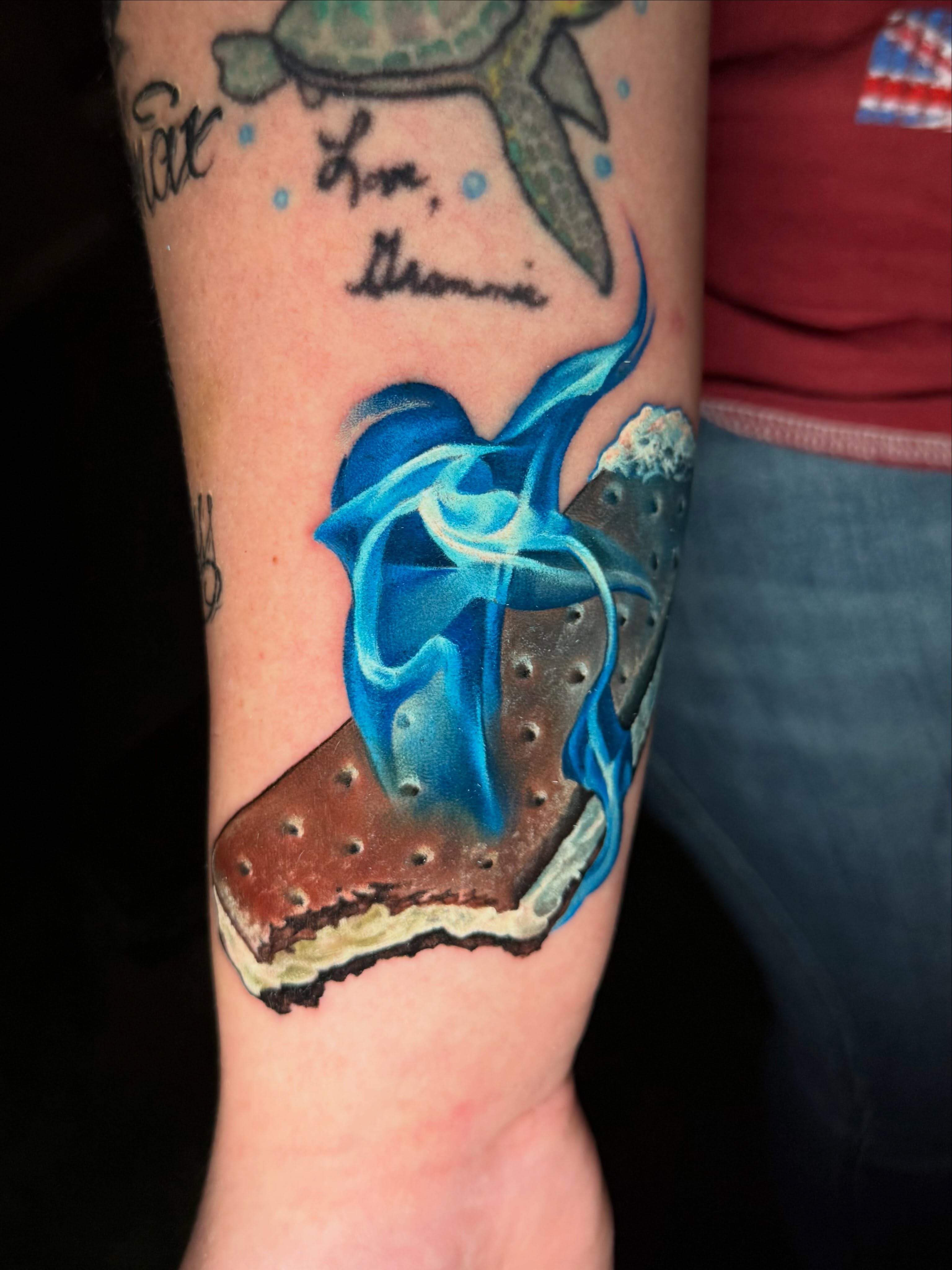 Smore with blue flames realism tattoo on the forearm by Derek Gardner